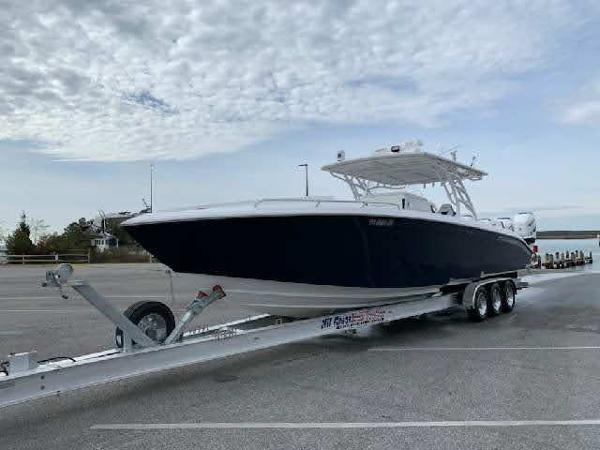 2019 Midnight Express 39 Cuddy boat on trailer under cloudy sky.