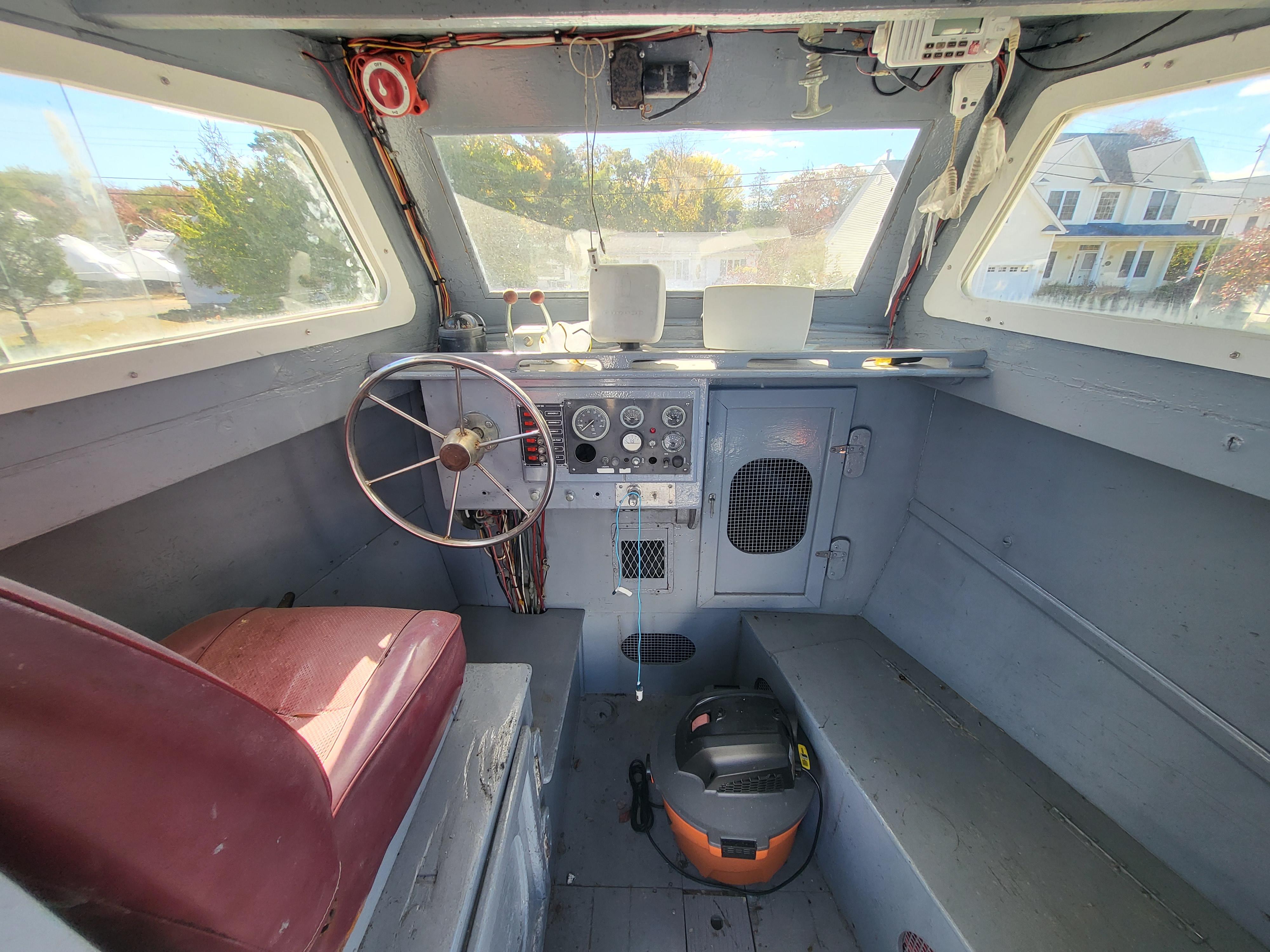 1985 Kinnamon Pilot House Chesapeake Deadrise interior with steering wheel and control panel.