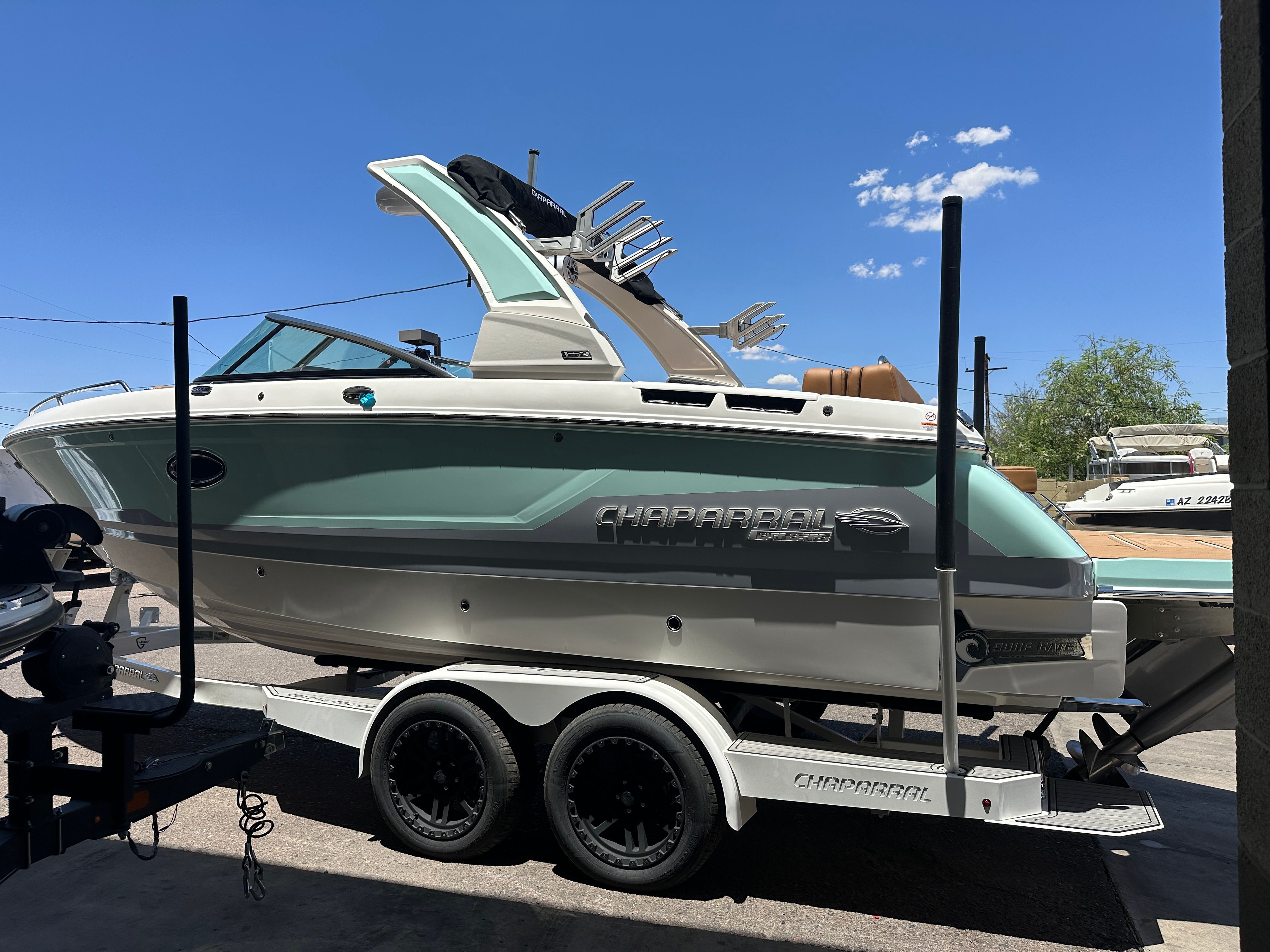 2025 Chaparral 26 Surf boat on a trailer outdoors.