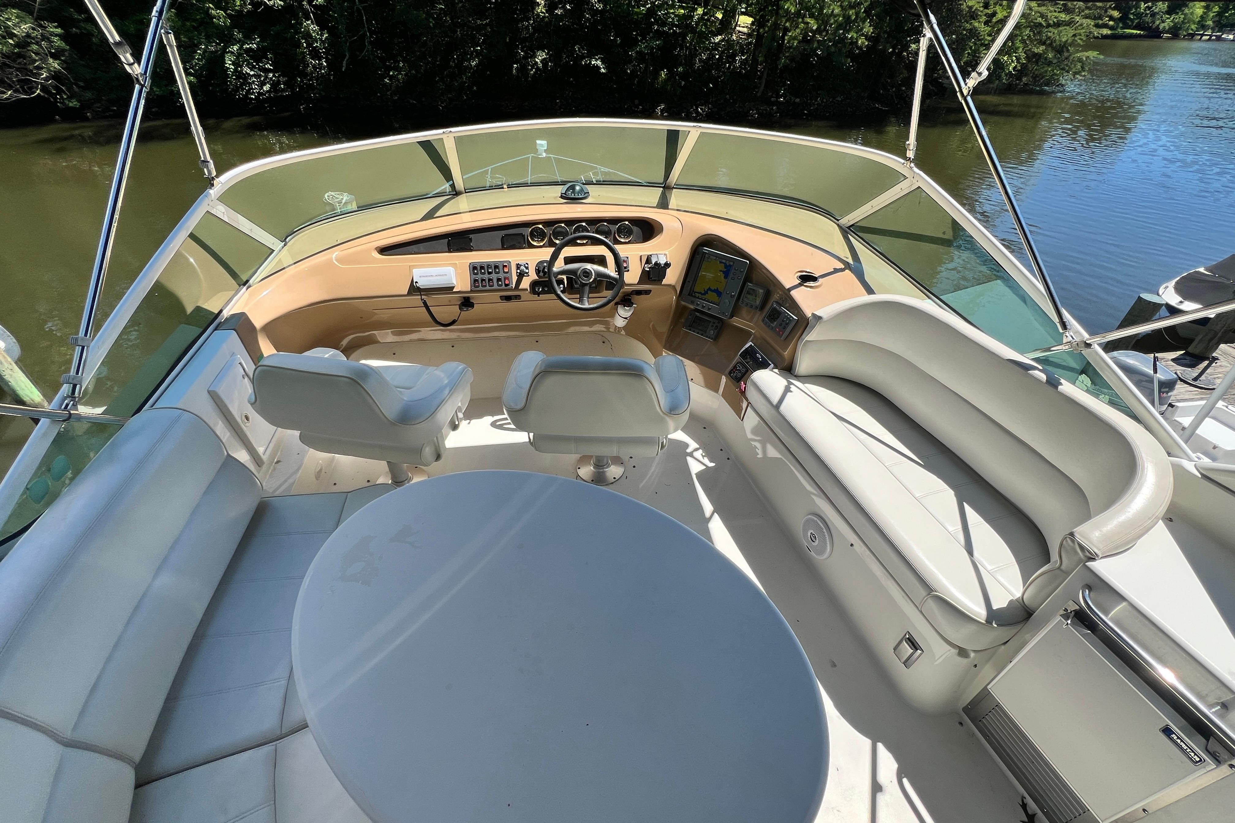 2003 Carver 450 Voyager Pilothouse helm with seating, steering wheel, and navigation equipment.