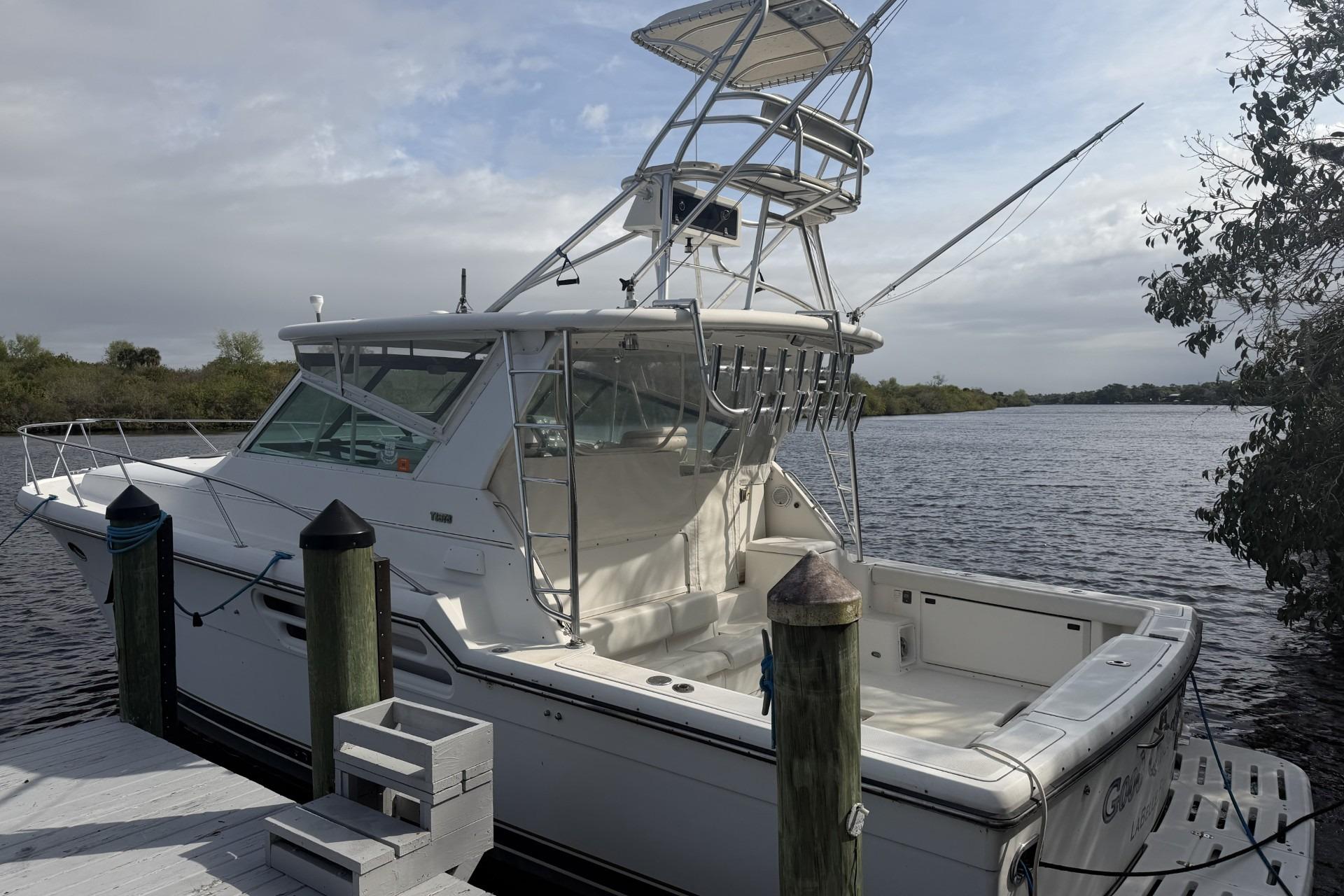 2000 Tiara Yachts 4100 Open docked by a serene river under cloudy skies.