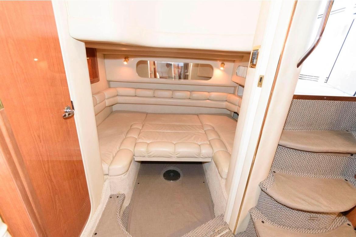 Interior cabin of 1999 Sea Ray Sundancer 400 yacht with plush seating and cozy ambiance.