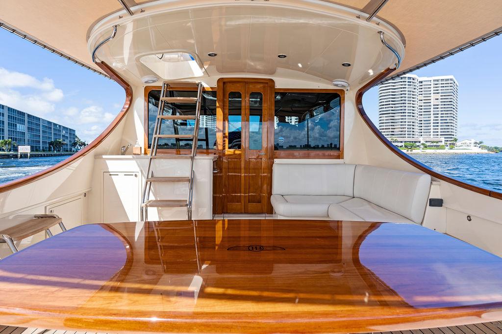 Luxurious 2018 Palm Beach Motor Yachts PB55 Flybridge with elegant wood table and waterfront view.