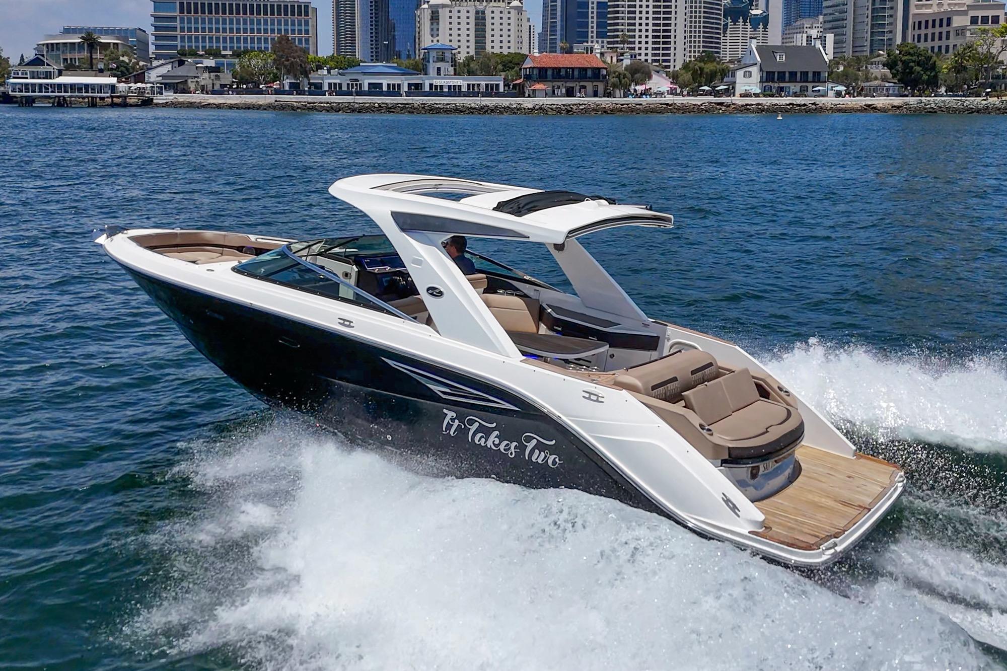 2018 Sea Ray SLX 310 cruising on water near city skyline.