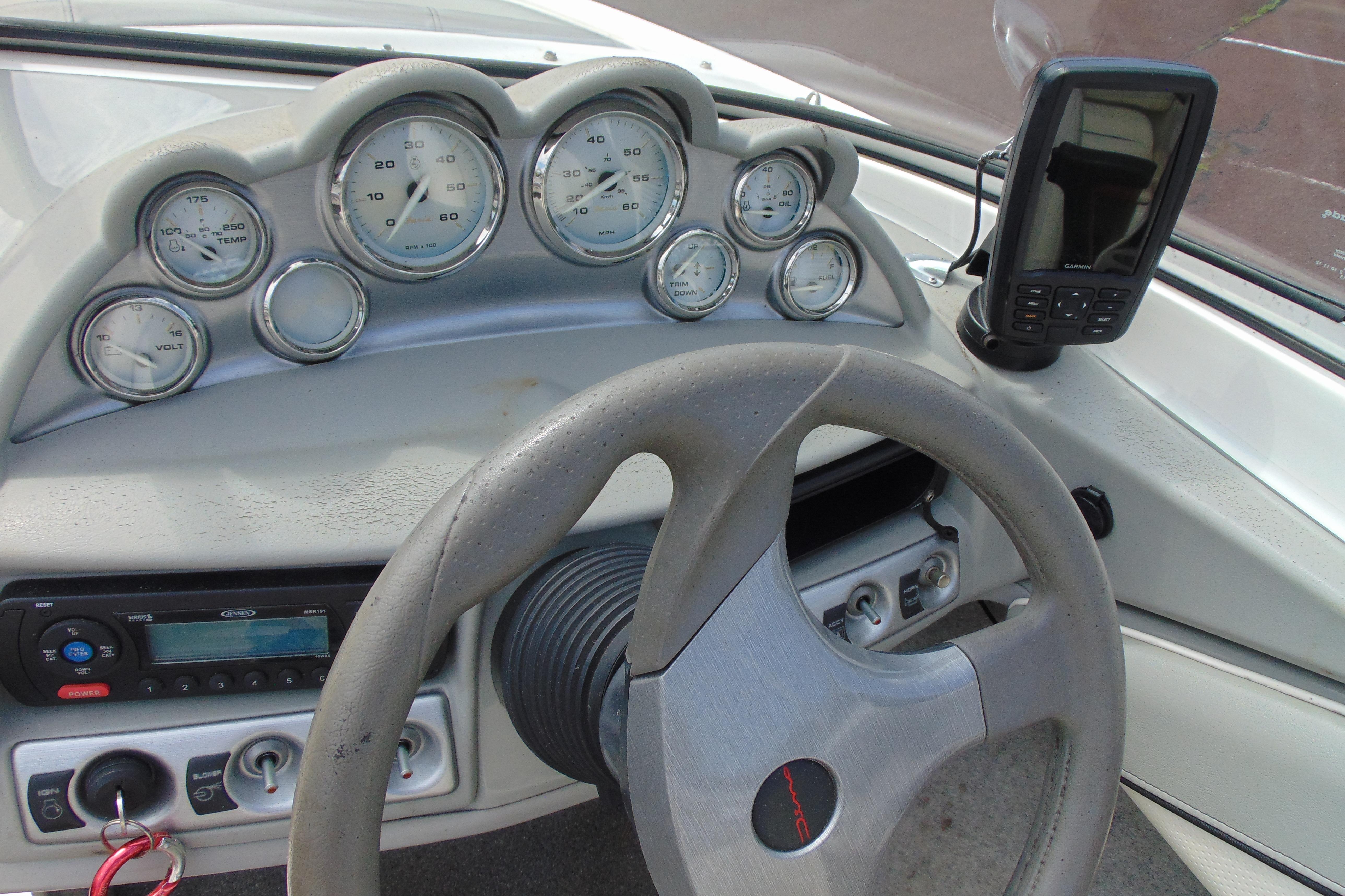 2012 Bayliner 185 Bowrider dashboard with gauges, steering wheel, and GPS device.