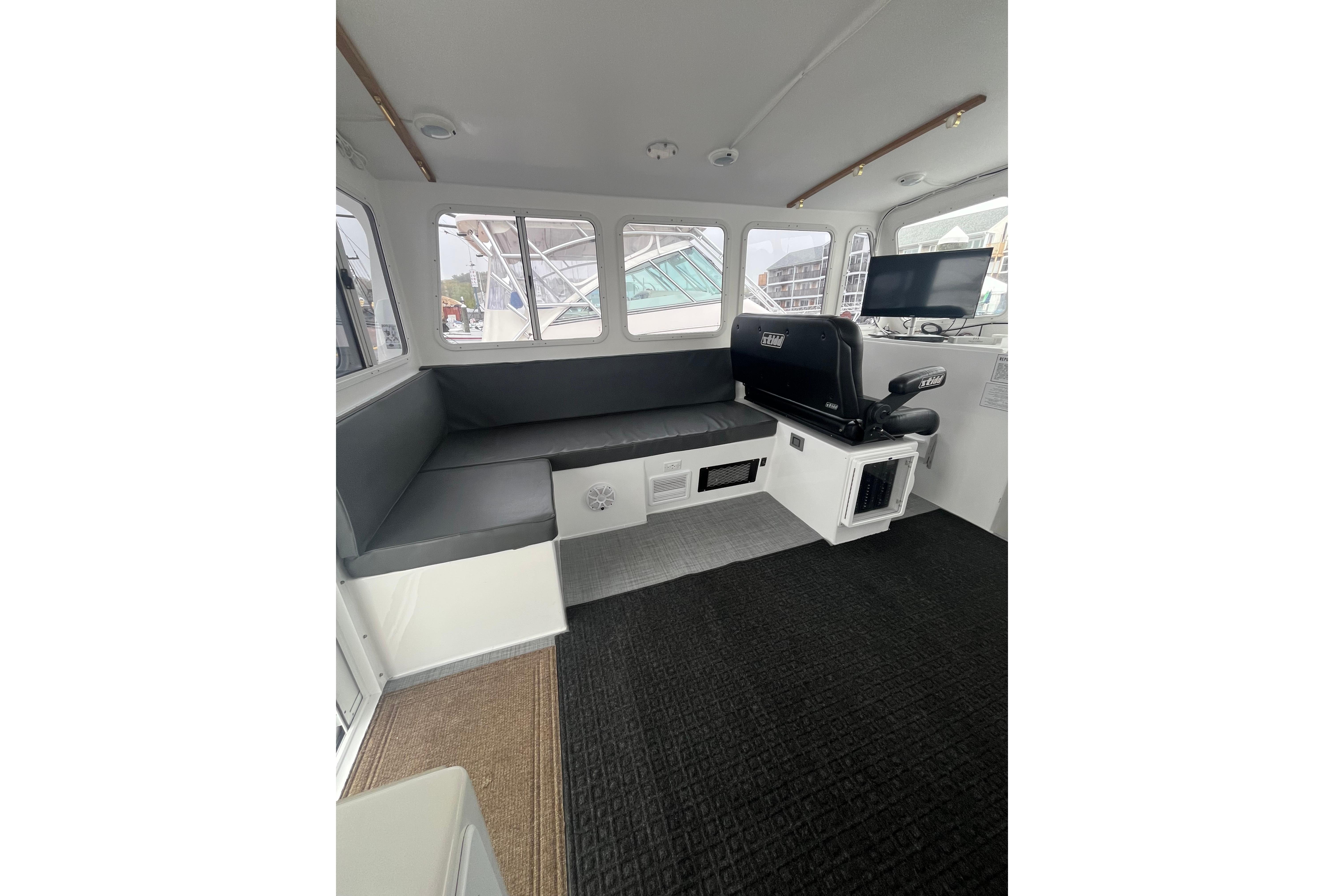 Interior of 2018 H&H Marine Osmond Beal boat with seating and navigation equipment.