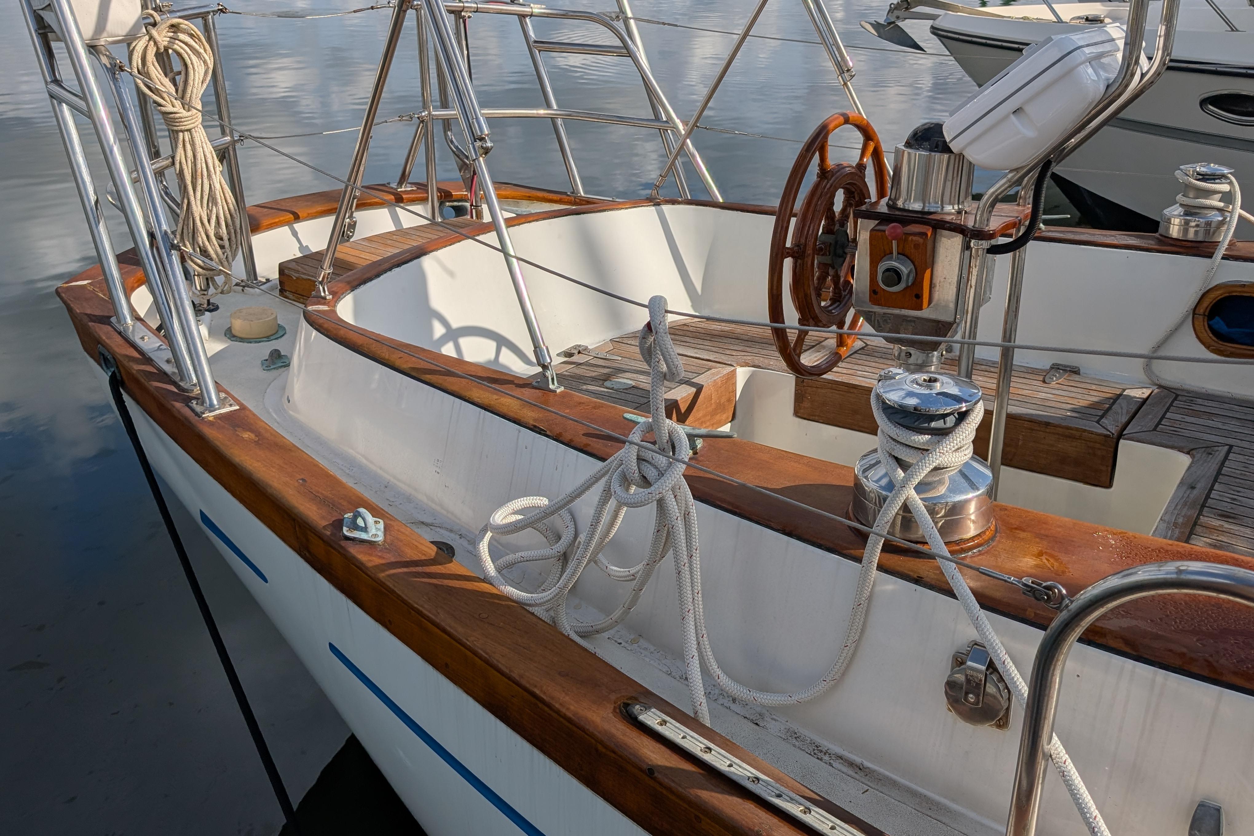 Cockpit of 1983 Robert Perry 41 sailboat with wooden accents and nautical ropes.