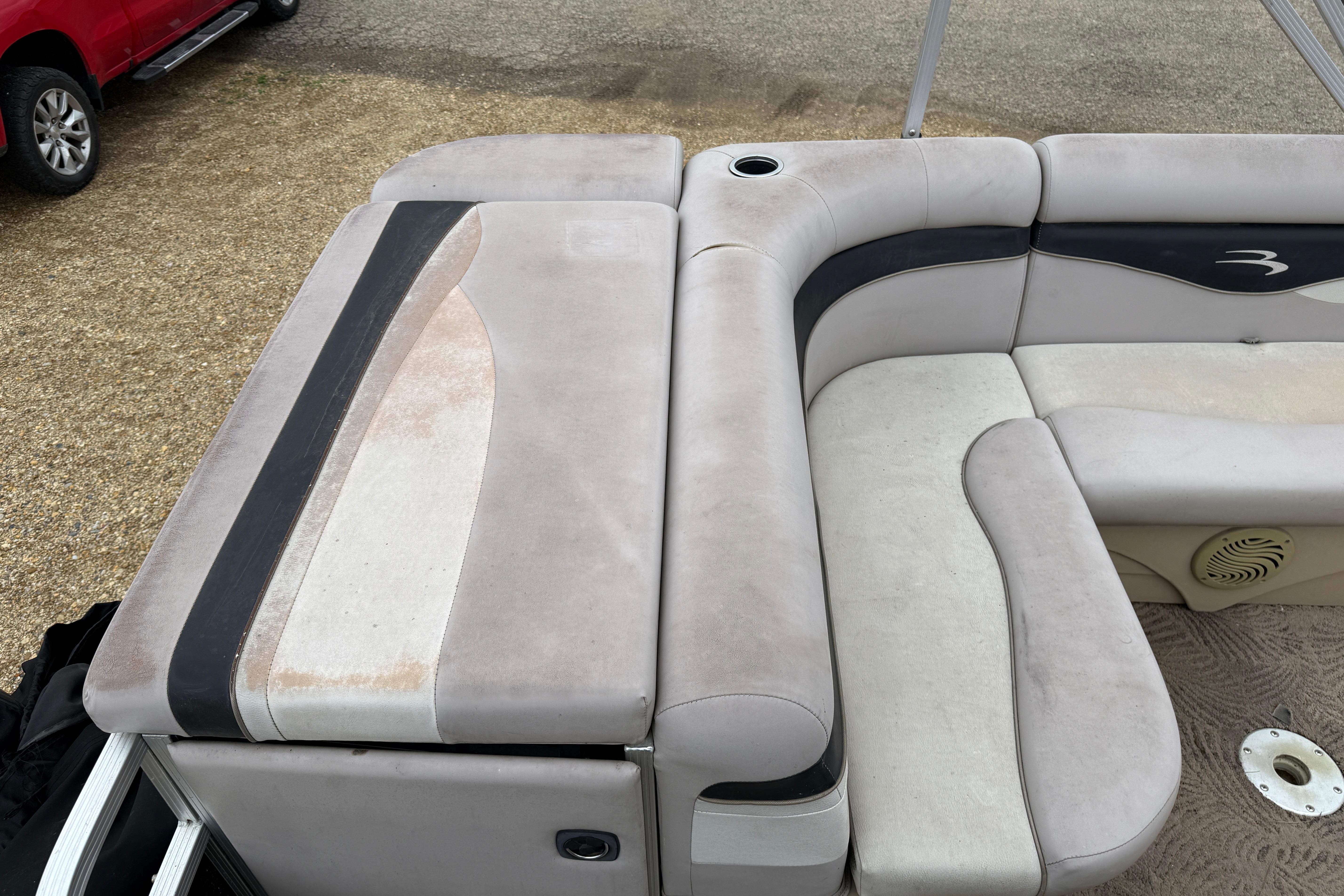 2010 Bennington 20SLi boat interior with beige and black seating, cup holder, and speaker.