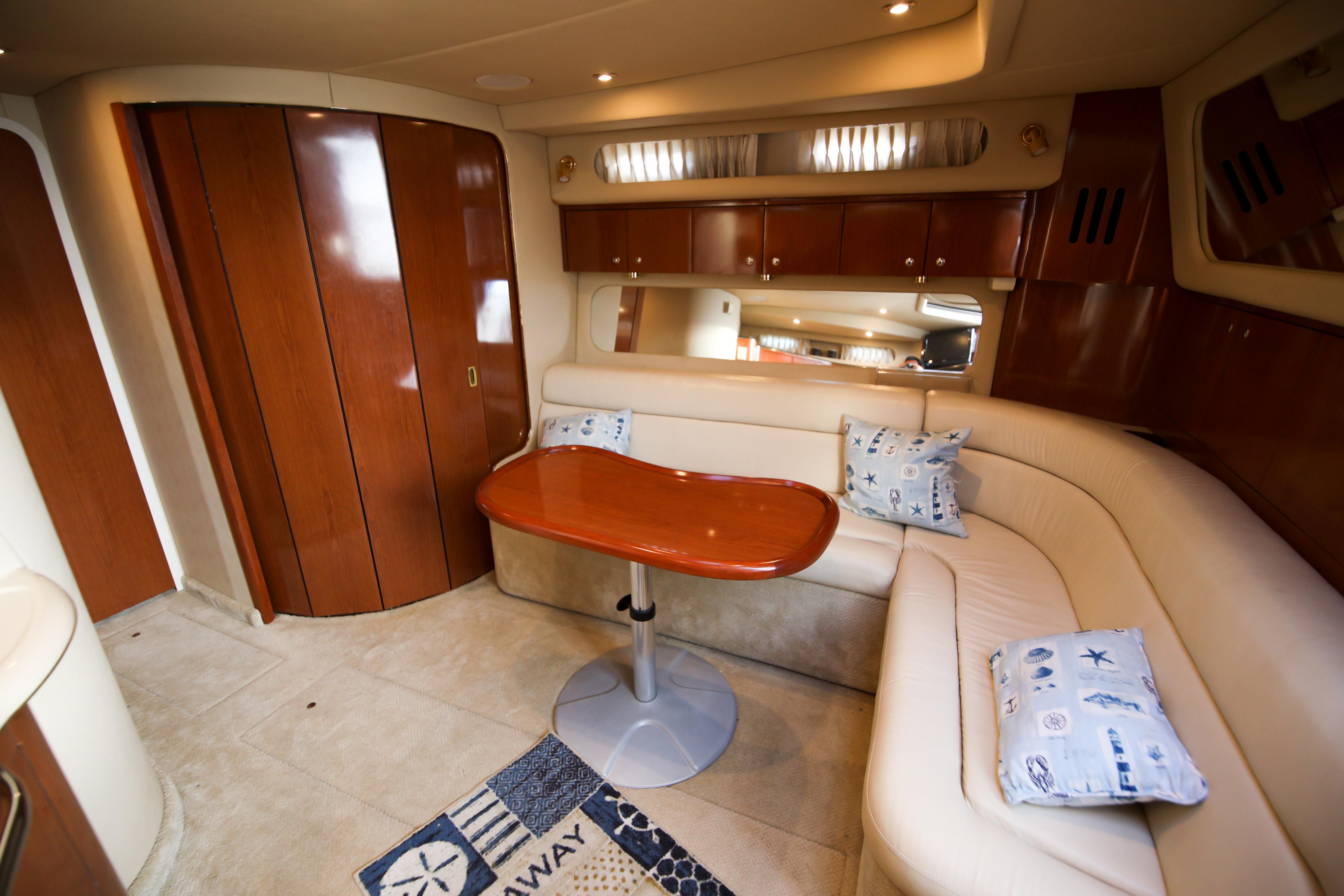 Interior of the 2002 Sea Ray 410 Express Cruiser with elegant seating area and wooden table.