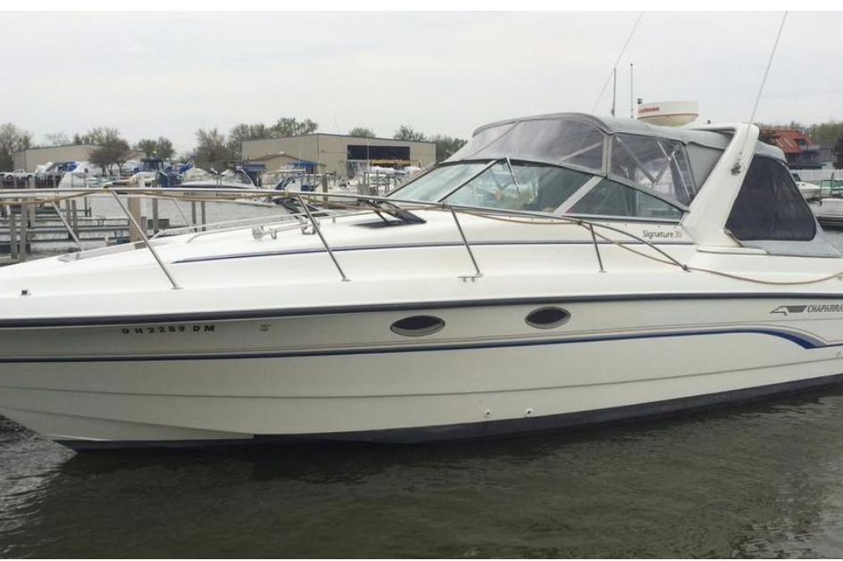 1992 Chaparral Signature 30 boat docked at marina, featuring sleek white design.