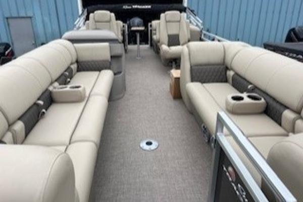 2024 Sun Tracker Party Barge 24 DLX interior with beige seating and cup holders.