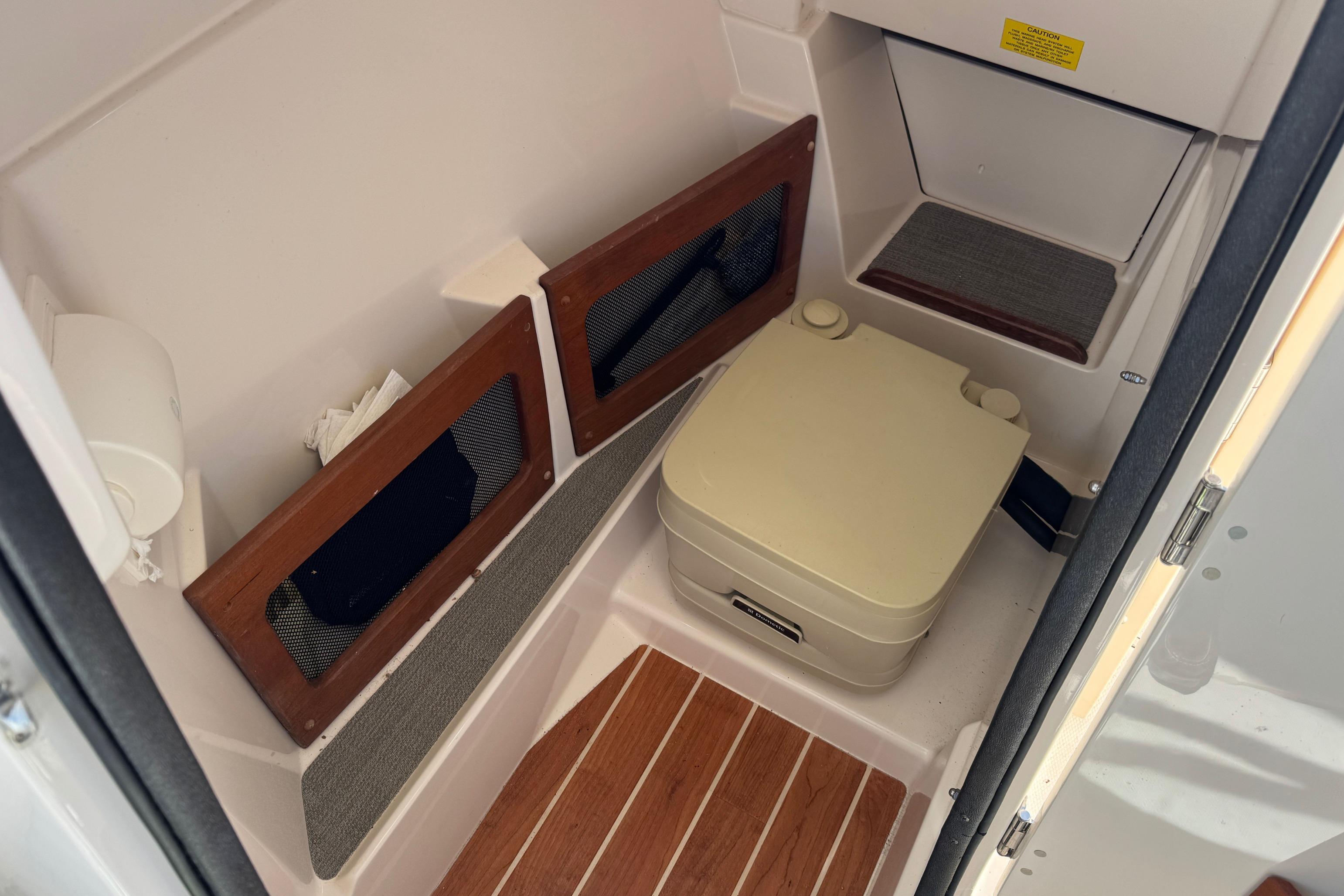 2017 Grady-White Freedom 235 boat interior with portable toilet and storage compartments.