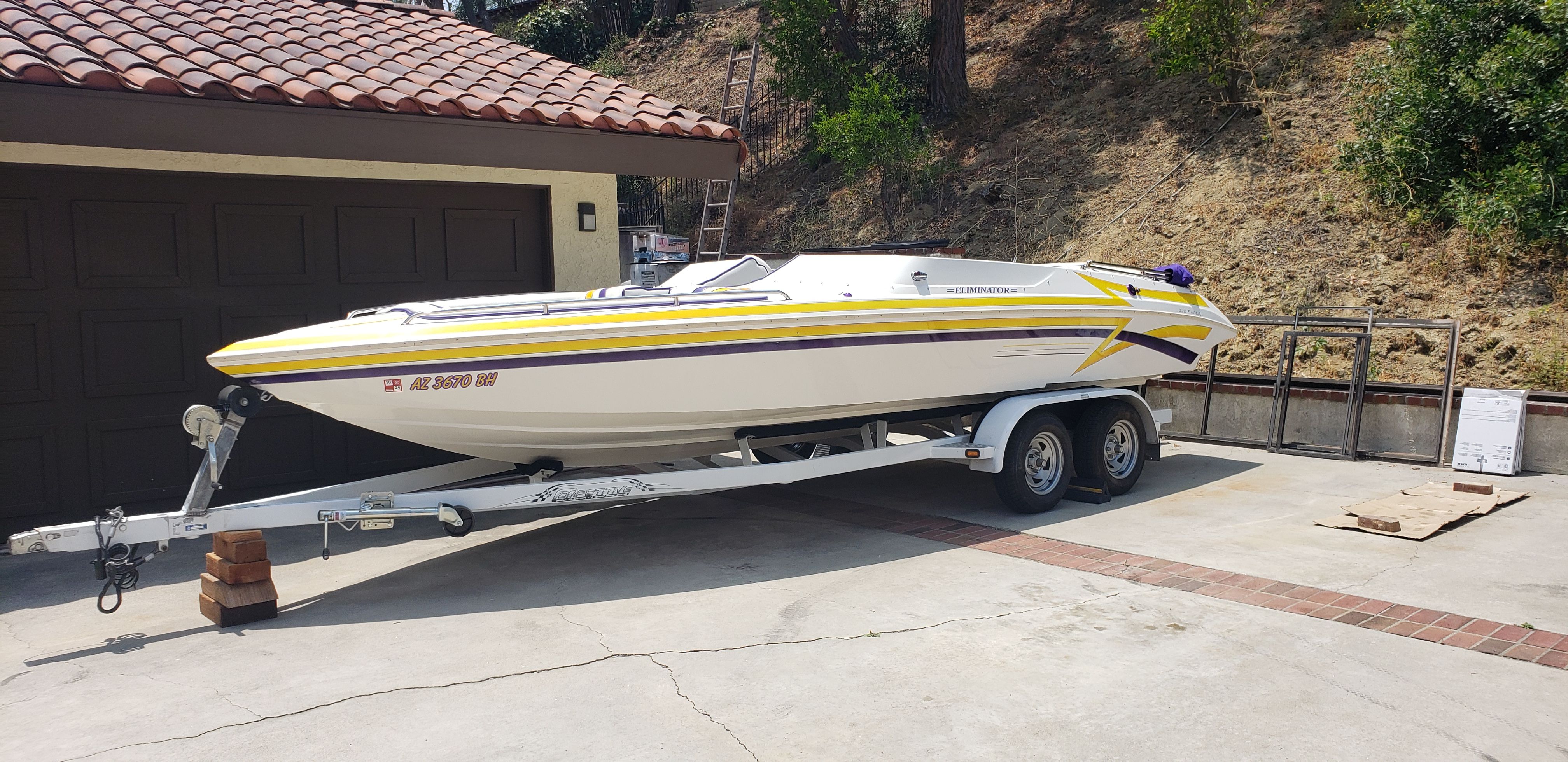 1999 Eliminator 220 Eagle XP boat on trailer in driveway.