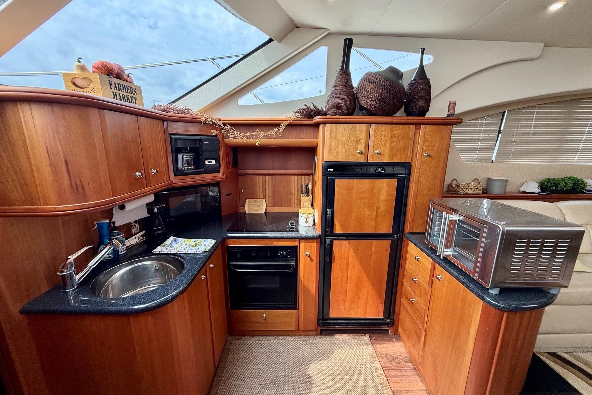 Luxurious 2004 Silverton 39 Motor Yacht kitchen with wood cabinetry and modern appliances.