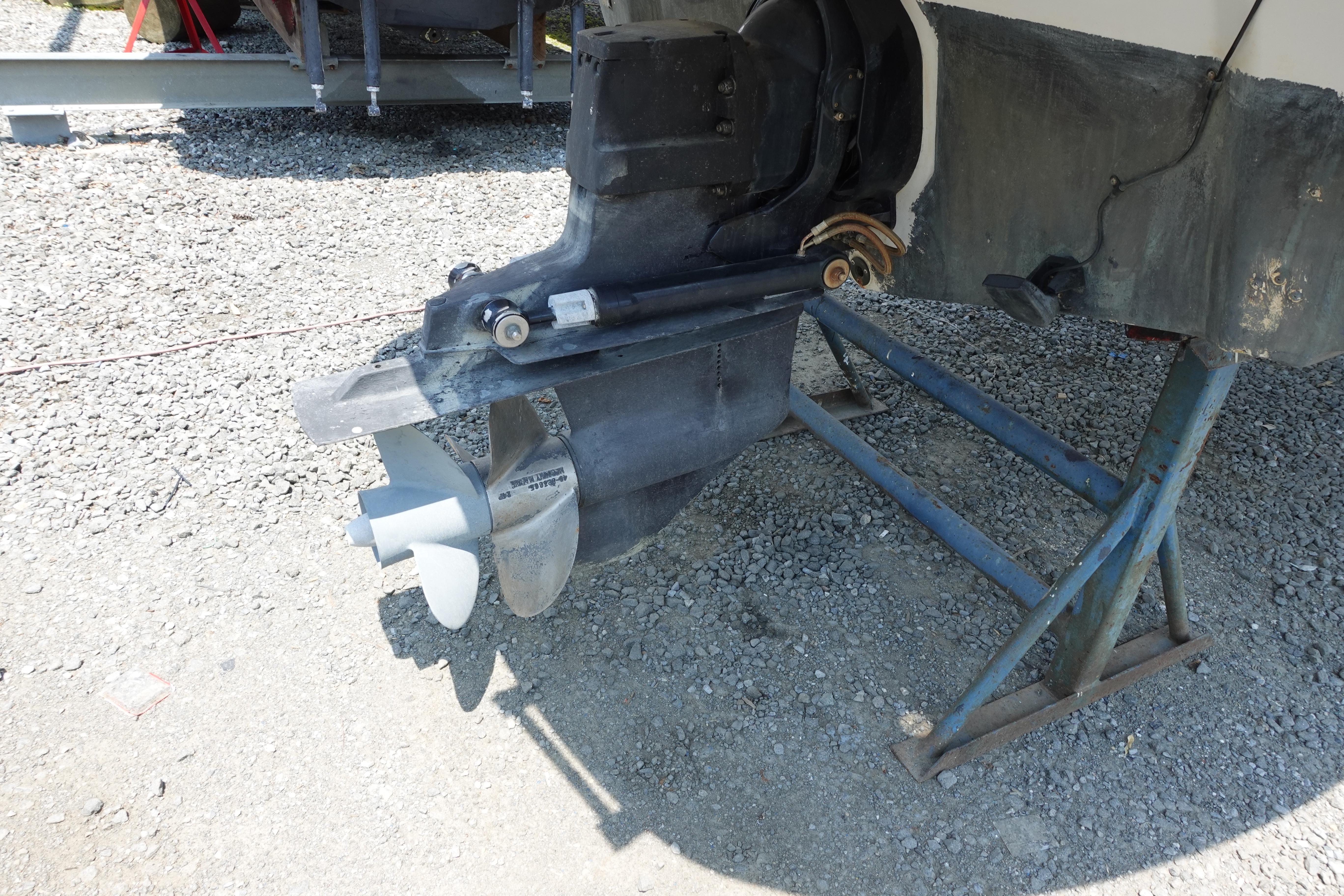 2004 Crownline 240 EX boat propeller and outdrive on gravel surface.