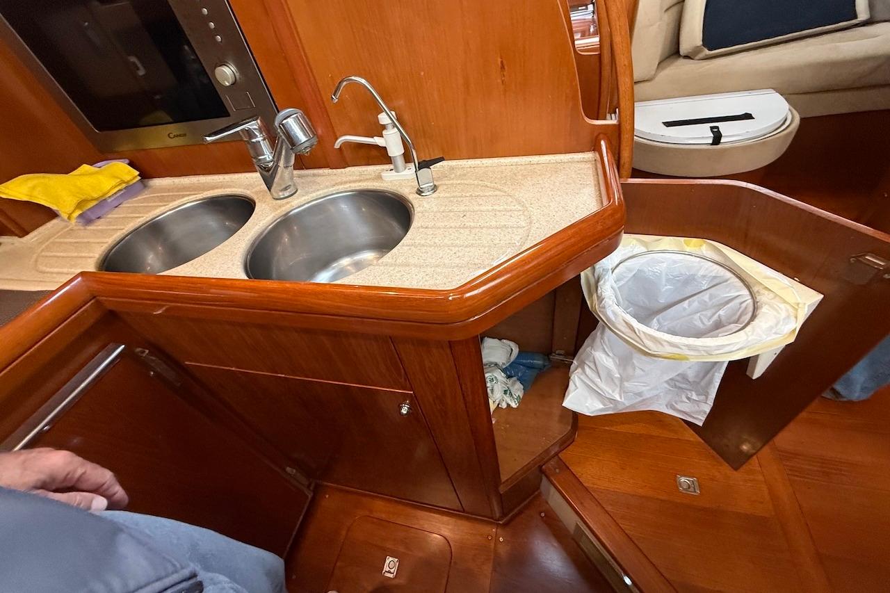 Galley of 2002 Moody 47 yacht with dual sinks and wooden cabinetry.