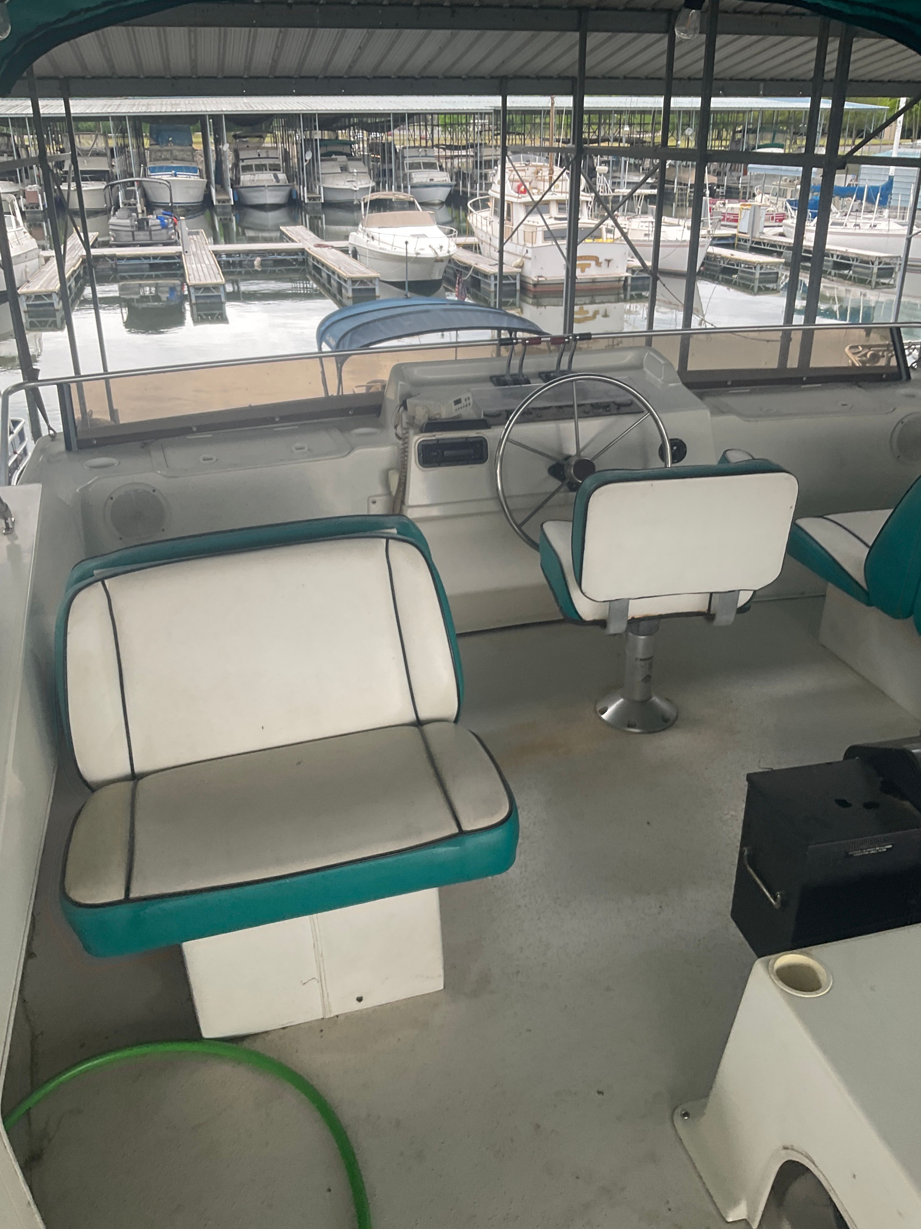 The image shows the helm of a 1996 Gibson 44 Standard with white and green seating.