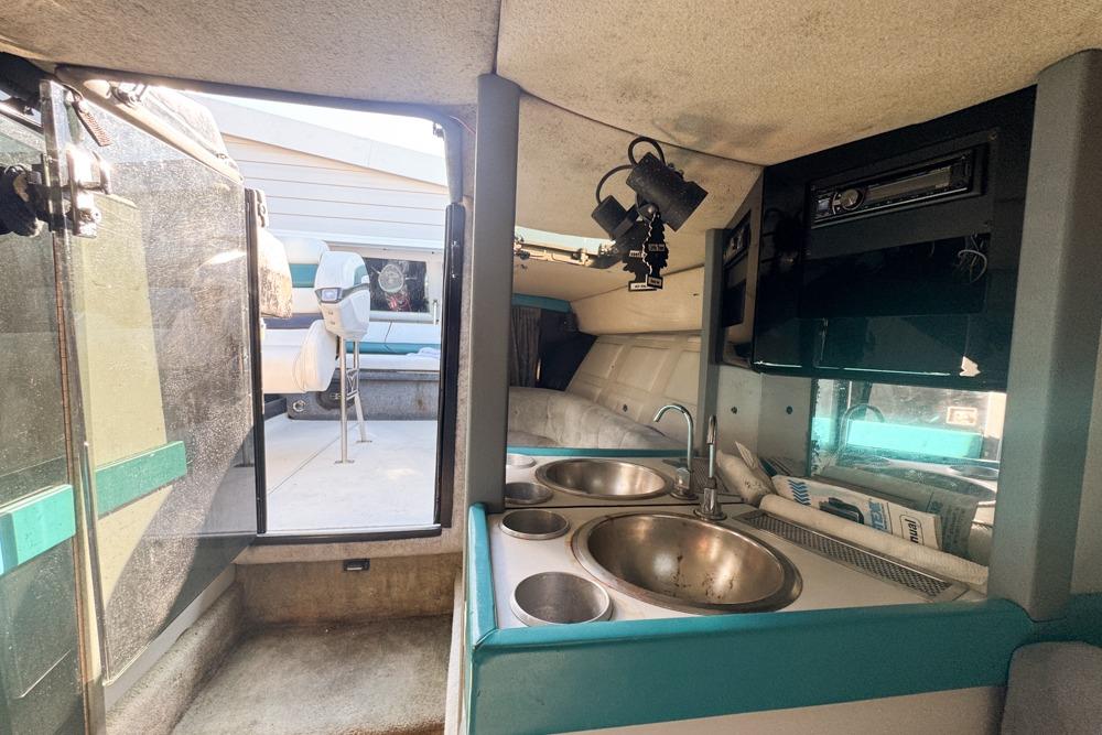 Interior of a 1989 Formula 292 SR-1 boat featuring a compact kitchenette and seating area.