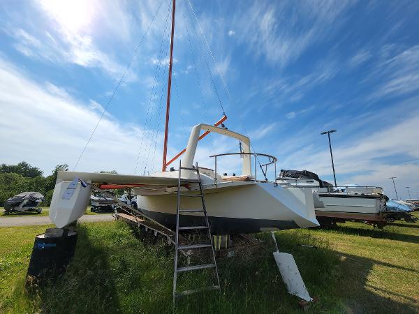 1985 Crowther Buccaneer sailboat on grass, clear sky, ladder leaning against hull.