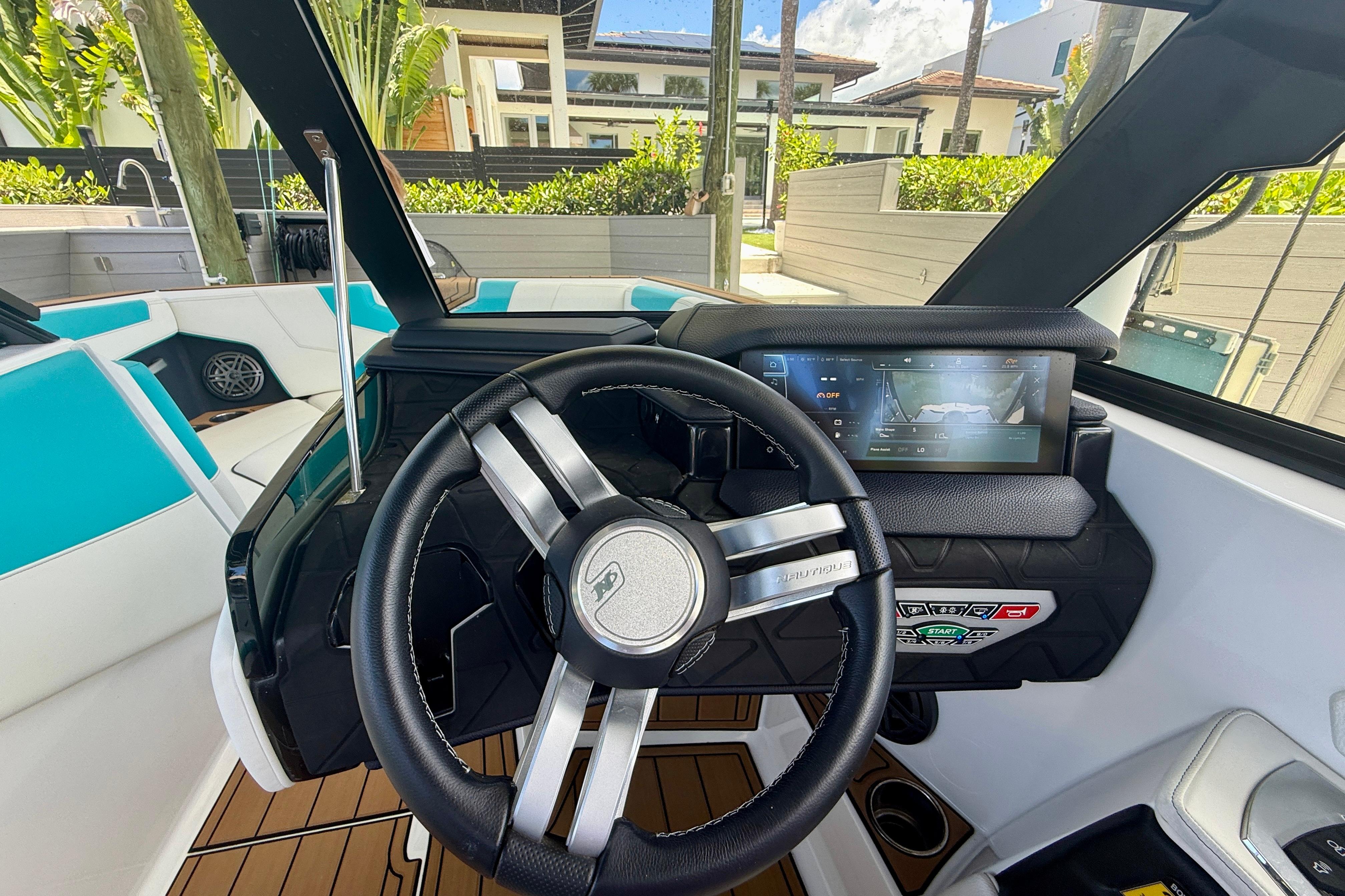 2024 Nautique Super Air Nautique GS20 dashboard with steering wheel and touchscreen display.