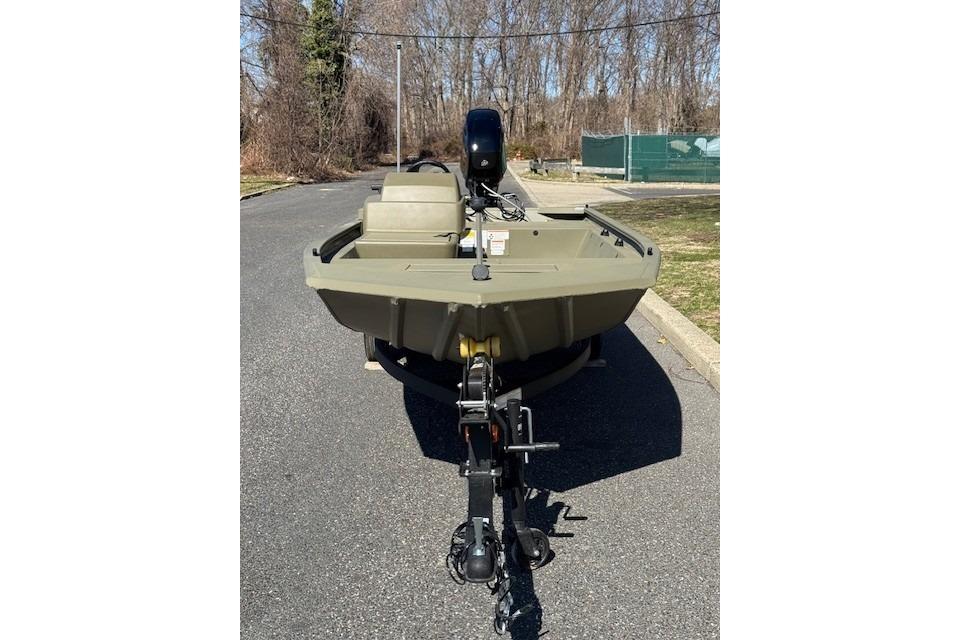 2026 Tracker Grizzly 1648 SC boat on trailer, parked on asphalt road.