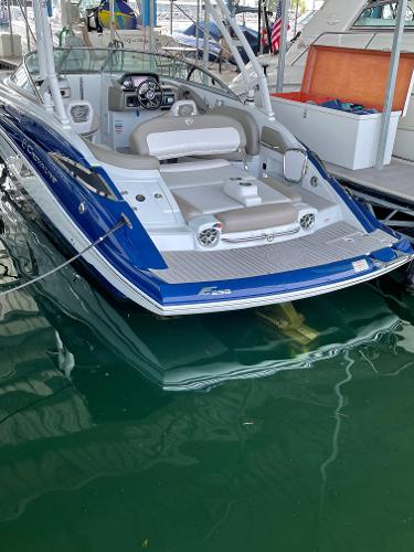 2019 Crownline E255 boat docked, featuring sleek blue and white design with comfortable seating.