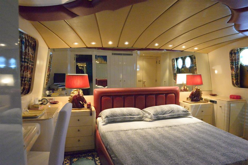 Luxurious bedroom interior on 1986 CRN 120 yacht with elegant lighting and decor.
