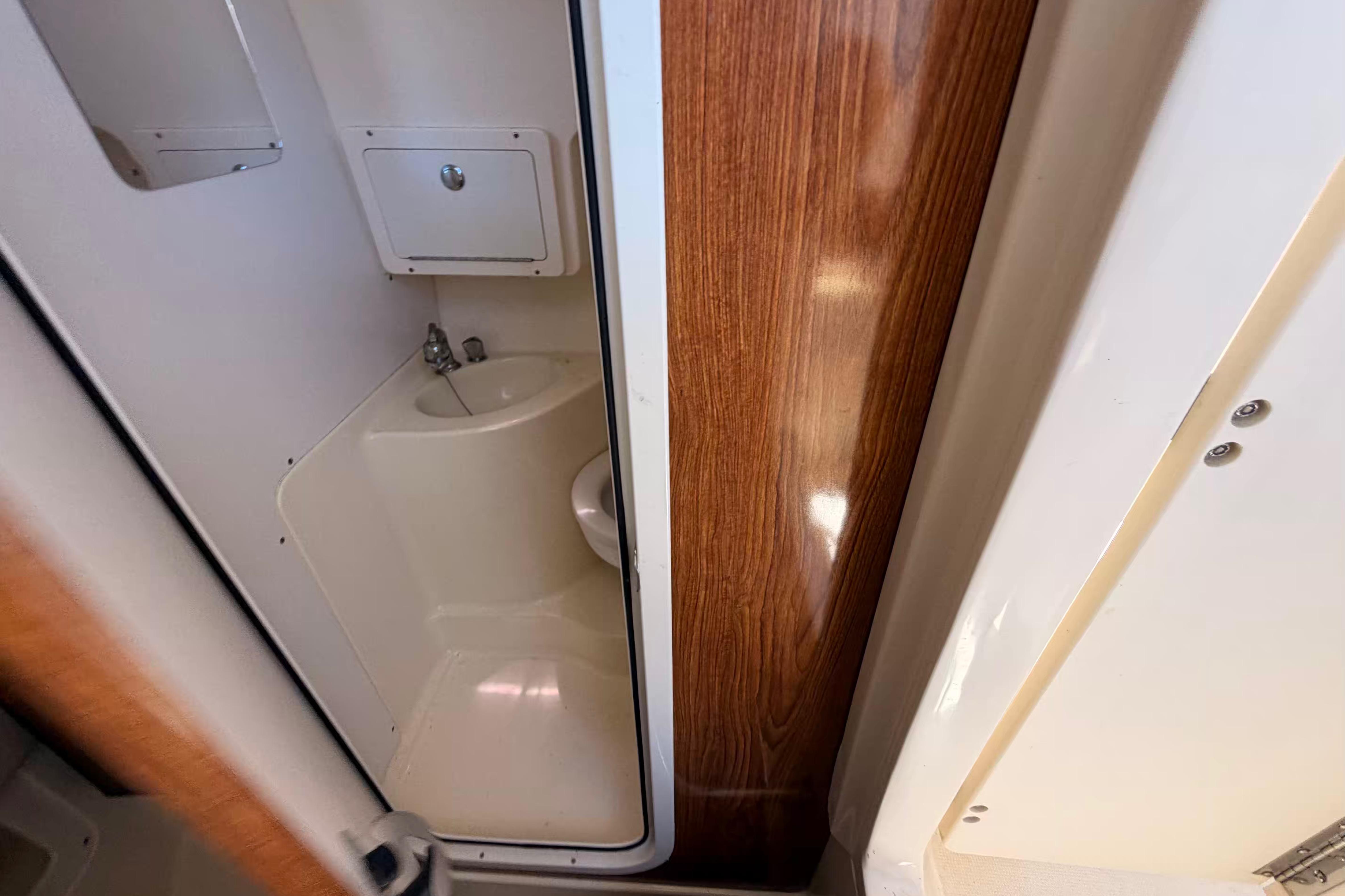 2007 Scout 262 Abaco boat interior with compact bathroom and wooden paneling.