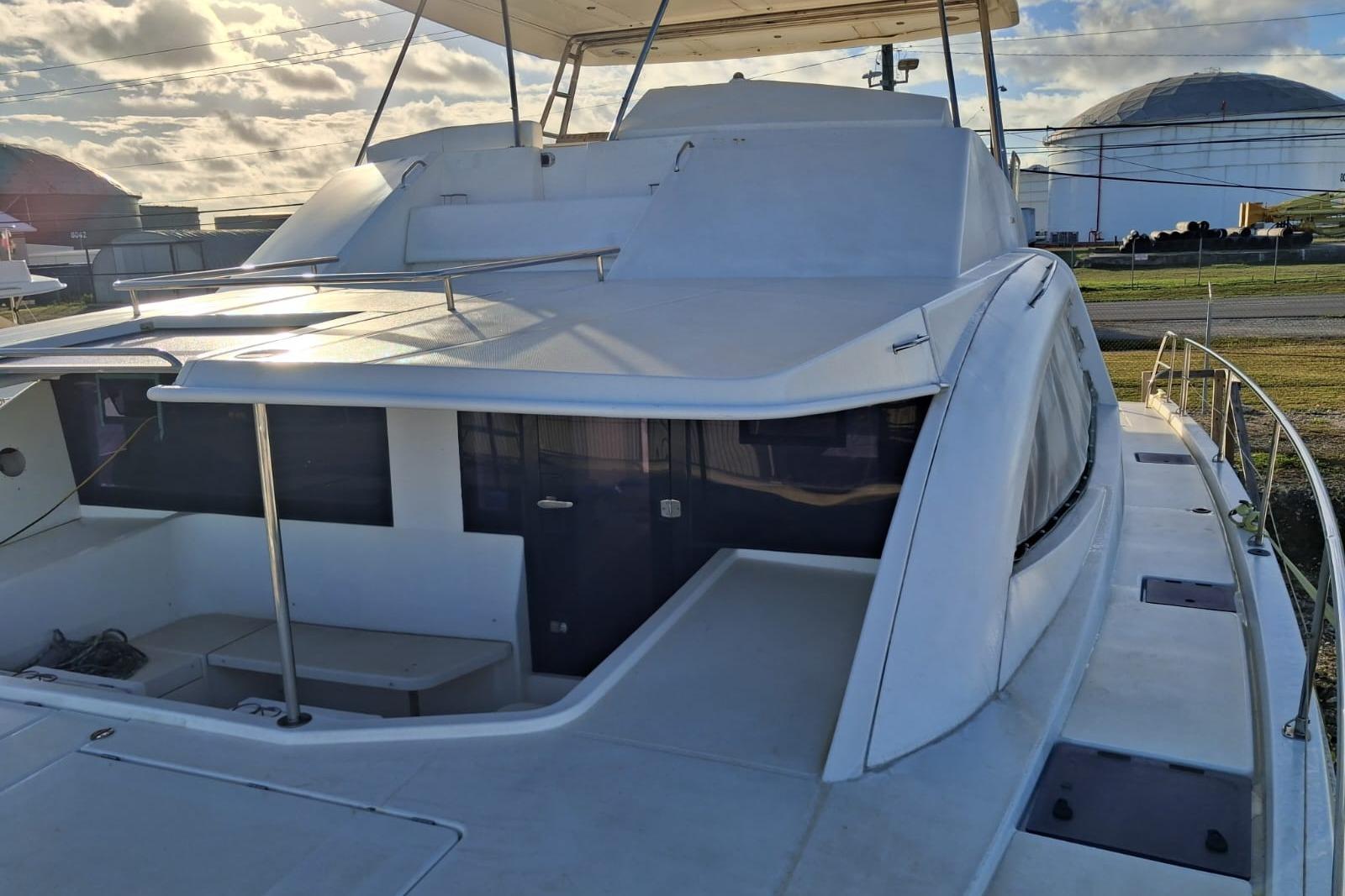 2015 Leopard 51 Powercat yacht docked, showcasing sleek design and spacious deck under cloudy sky.