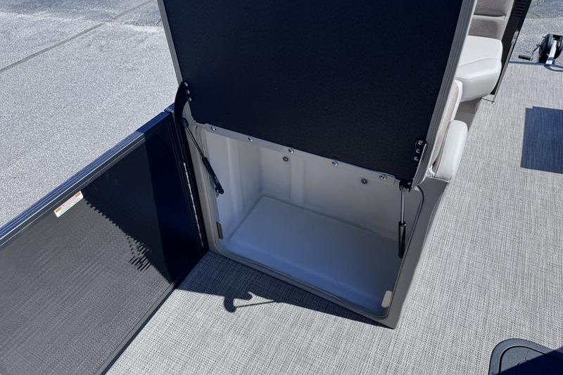 Open storage compartment on 2027 Manitou Aurora 23 RF SHP boat, showcasing interior space.