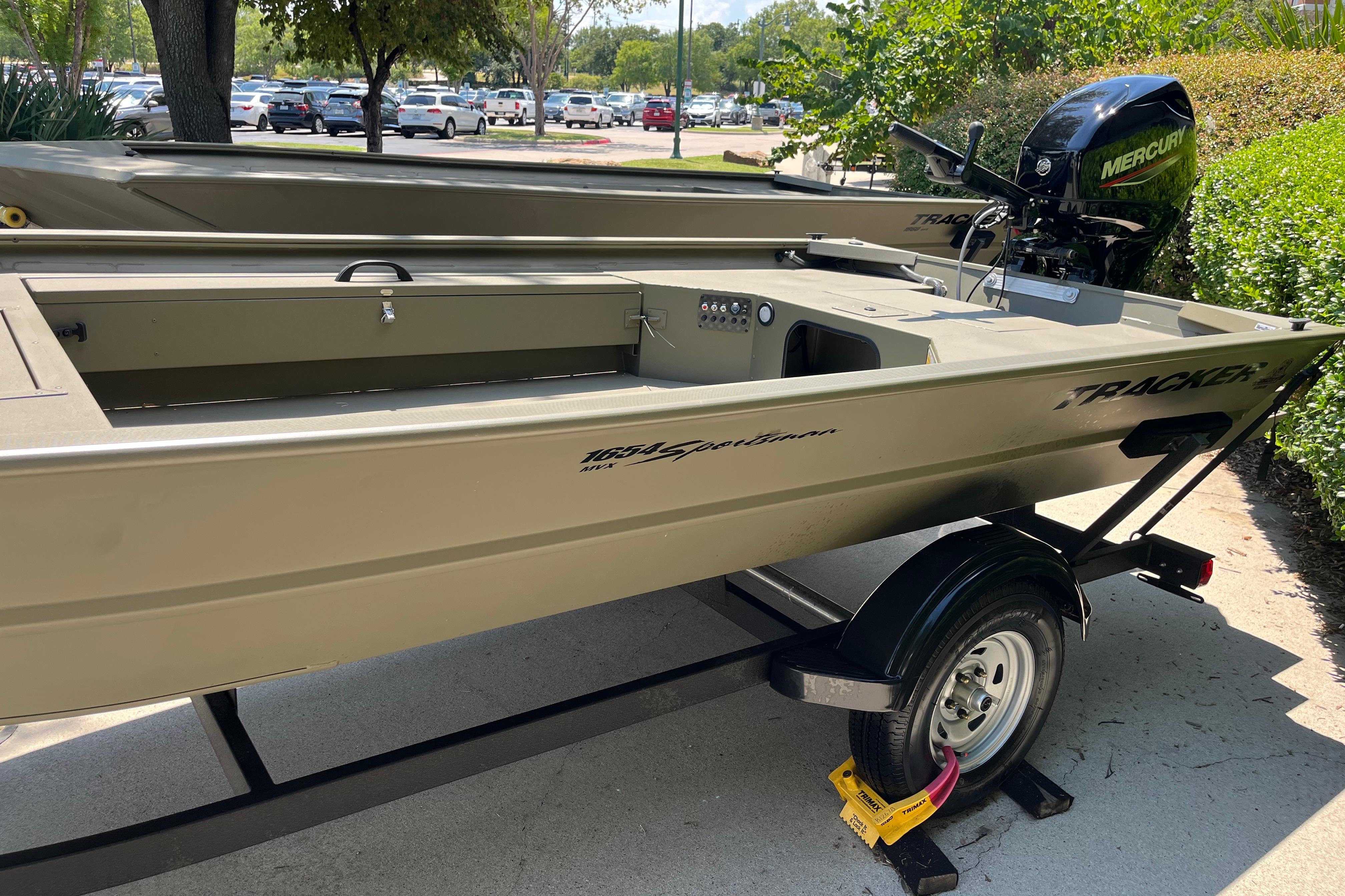 2026 Tracker Grizzly 1654 T Sportsman boat on trailer, parked outdoors.
