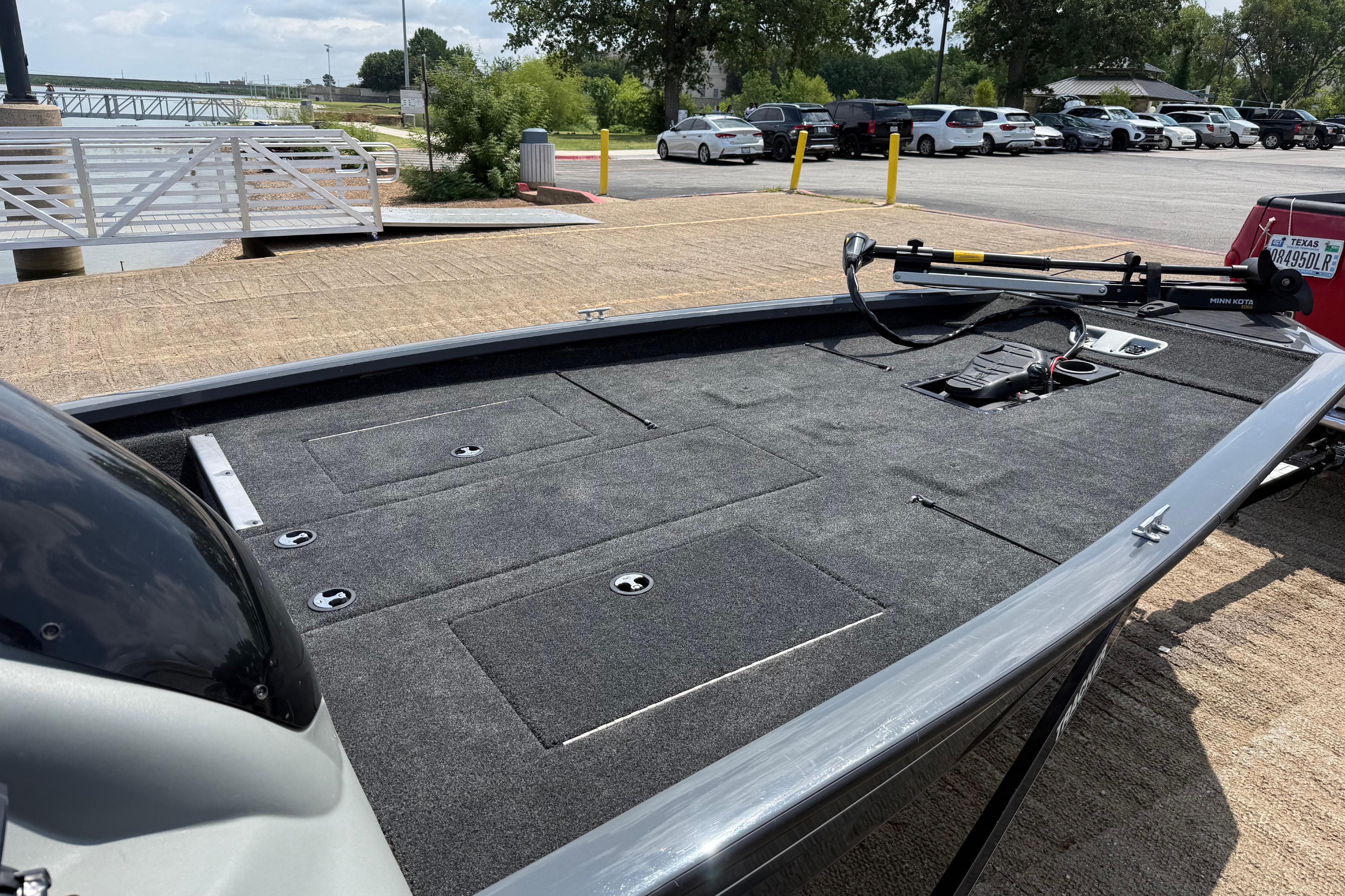 2015 Tracker Pro Team 190 TX boat at dockside, featuring spacious deck and storage compartments.