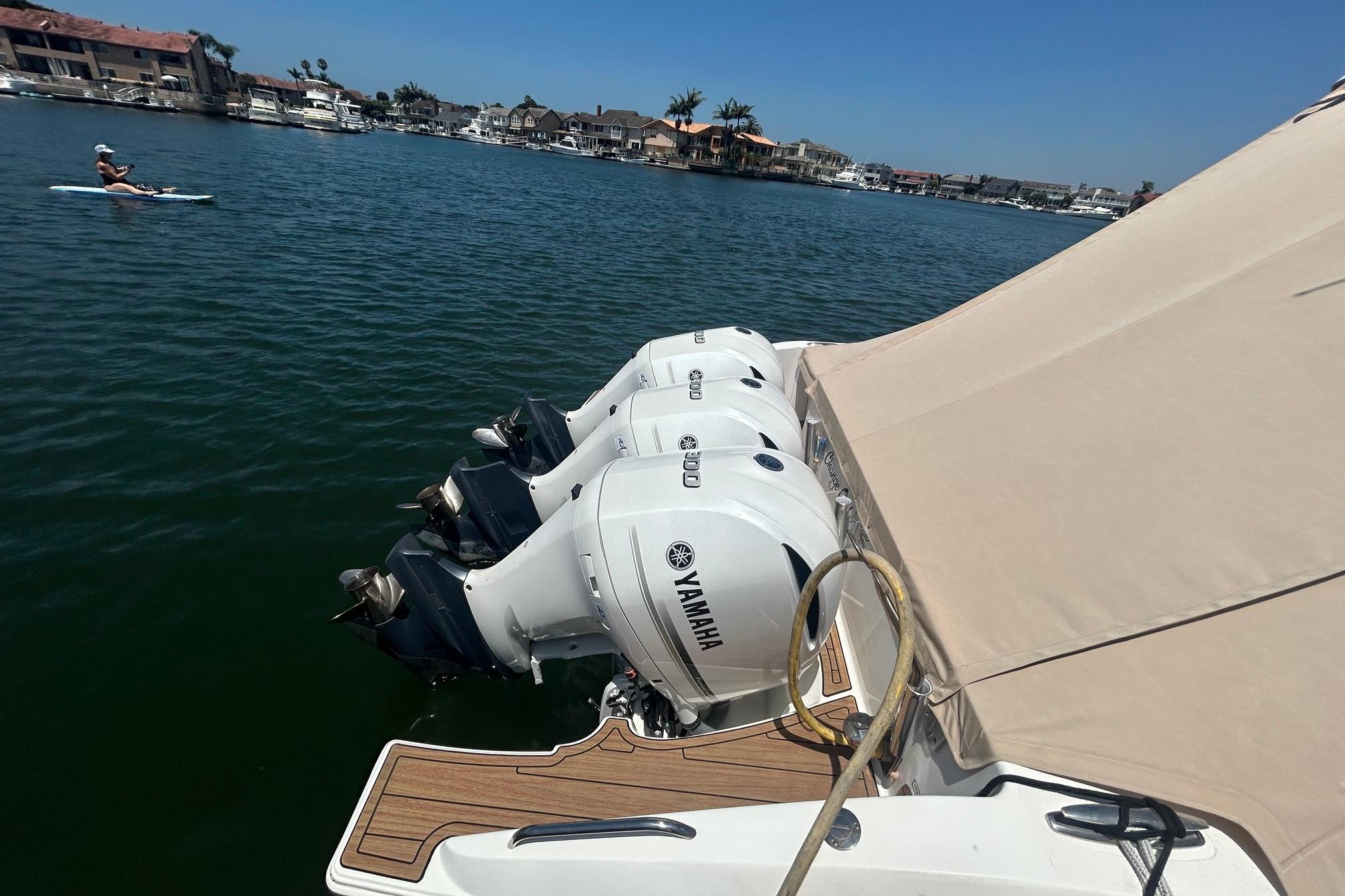 2019 Pursuit OS 355 Offshore with Yamaha engines docked near waterfront homes.
