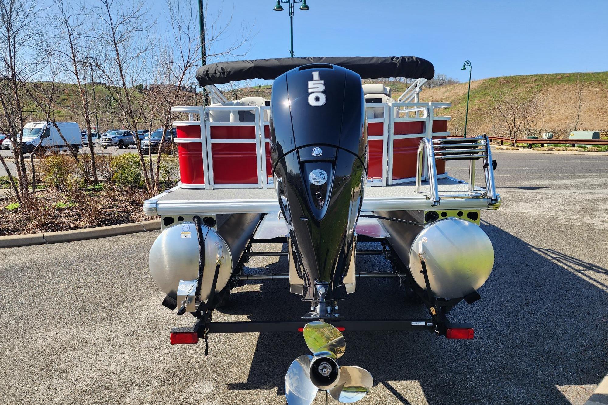 2026 Sun Tracker Fishin' Barge 22 DLX pontoon boat with powerful outboard motor.