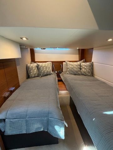 Interior of the 2017 Tiara Yachts C44 Coupe with twin beds and elegant lighting.