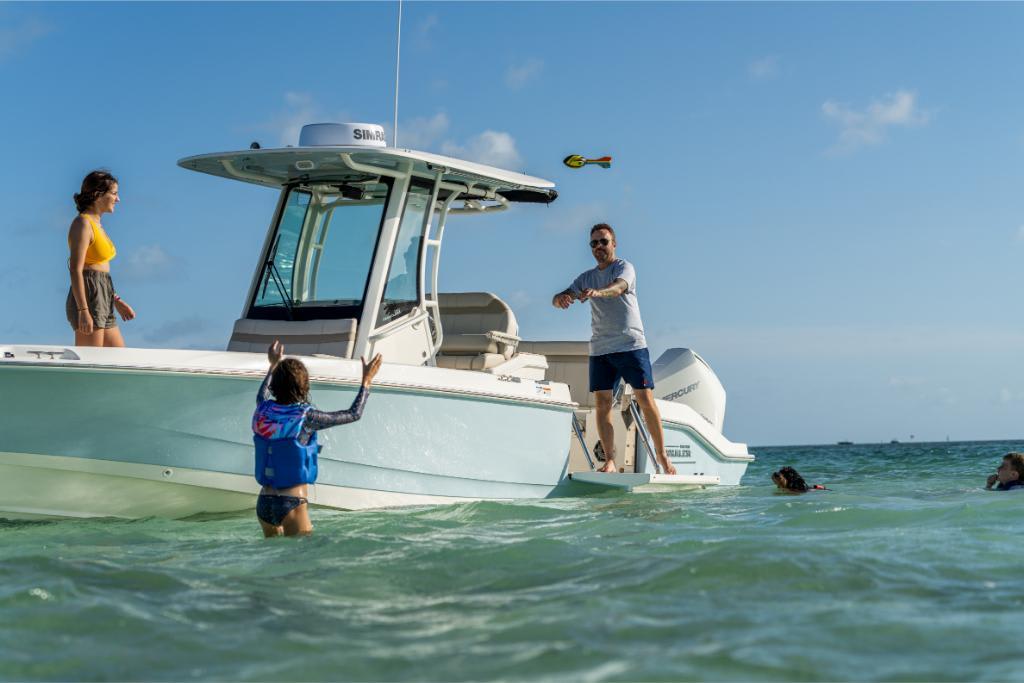 Family enjoying water activities near 2024 Boston Whaler 280 Dauntless boat.