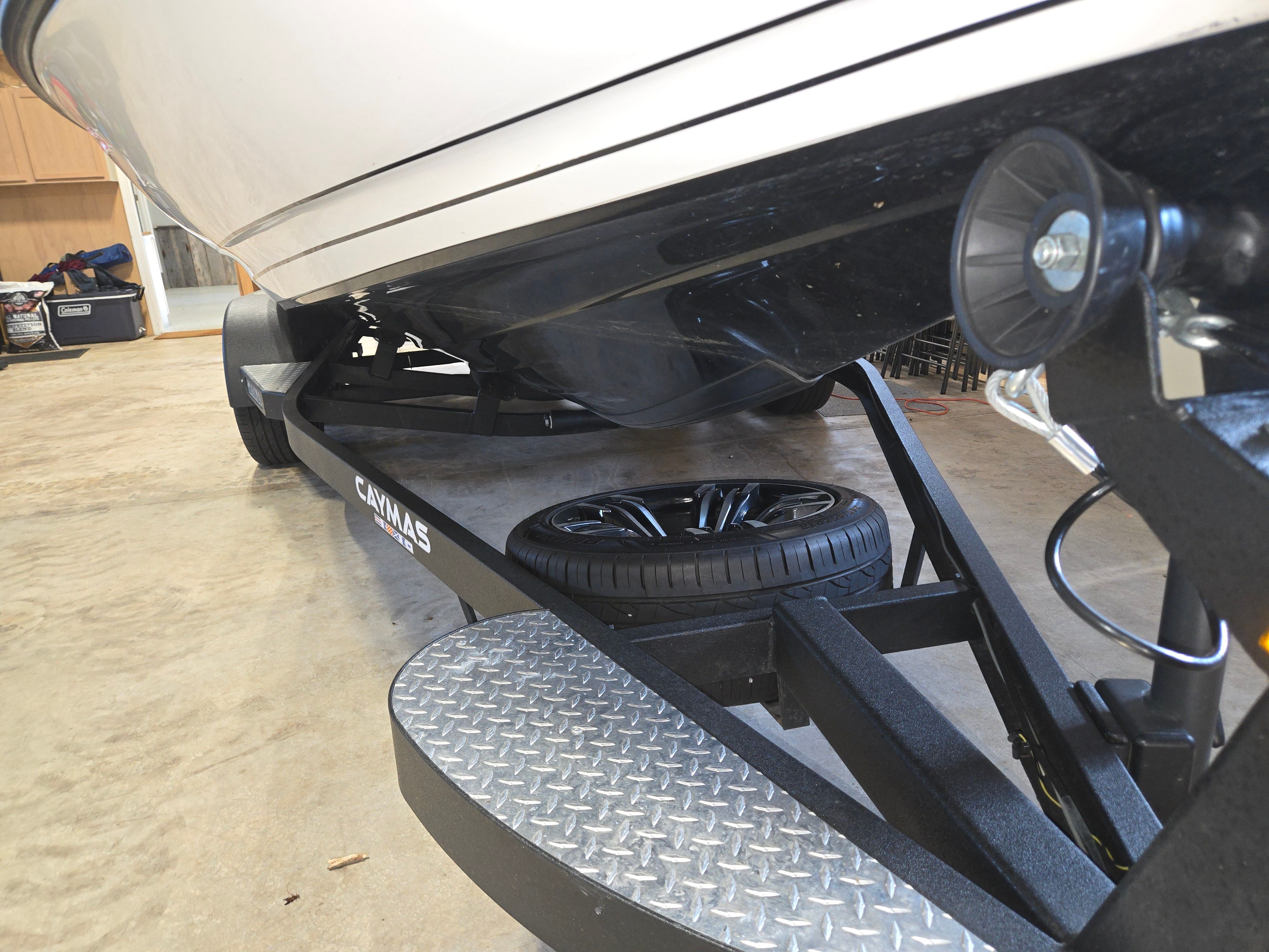 Close-up of a Caymas CX 19 boat on a trailer in a garage.