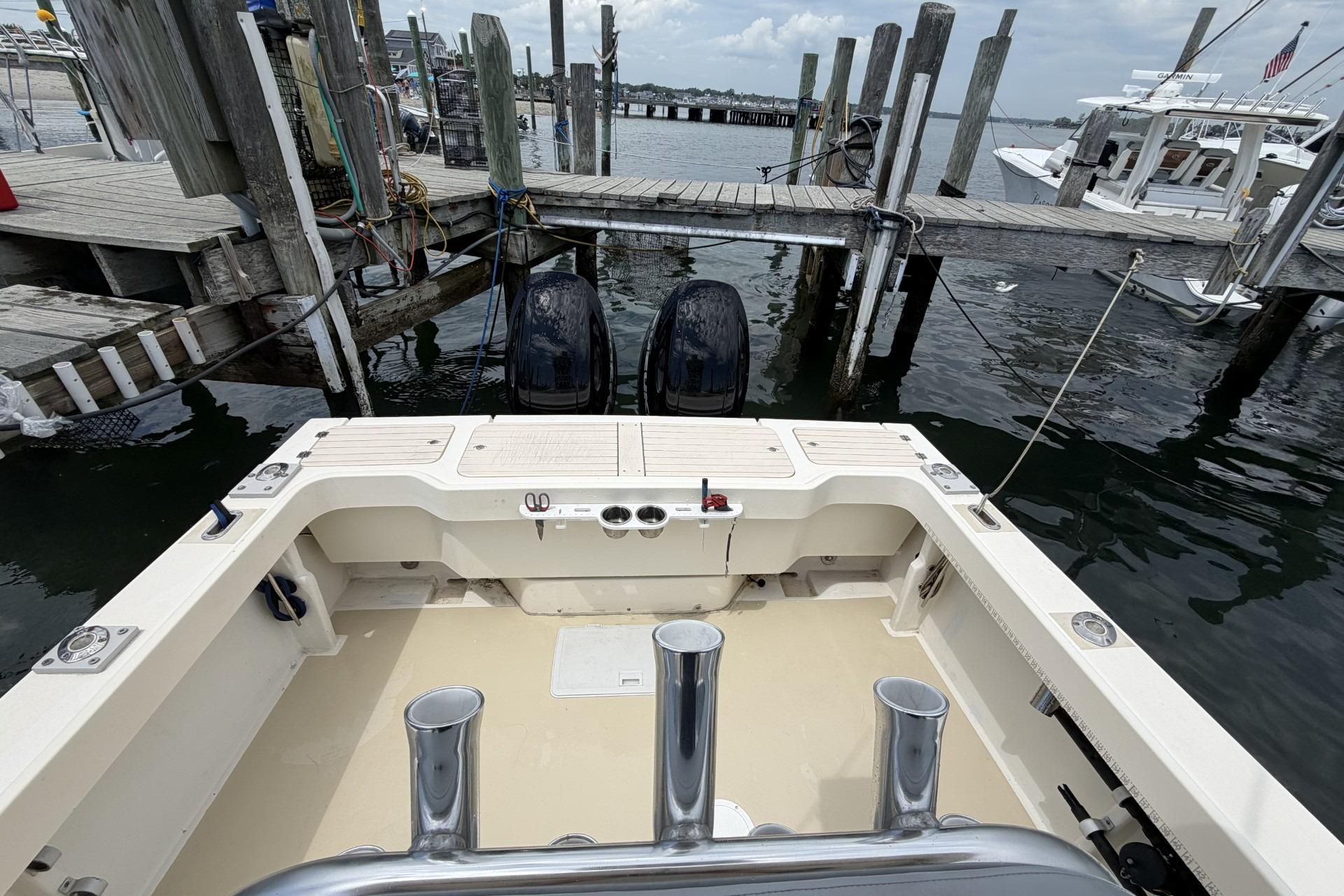 1999 Parker 2501 Center Console boat docked at a marina with dual outboard motors.