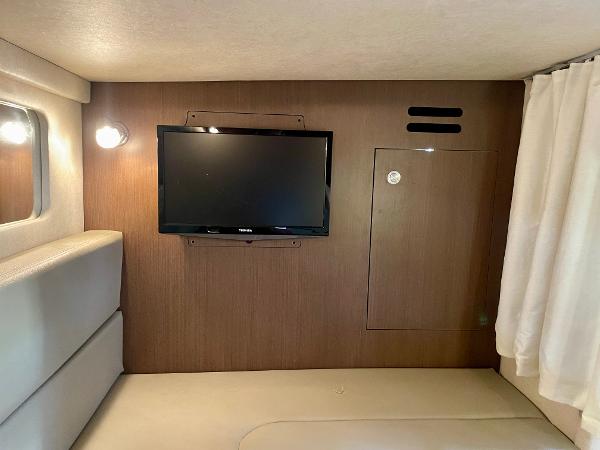 Interior of 2014 Sea Ray 330 Sundancer with mounted TV and cozy seating area.