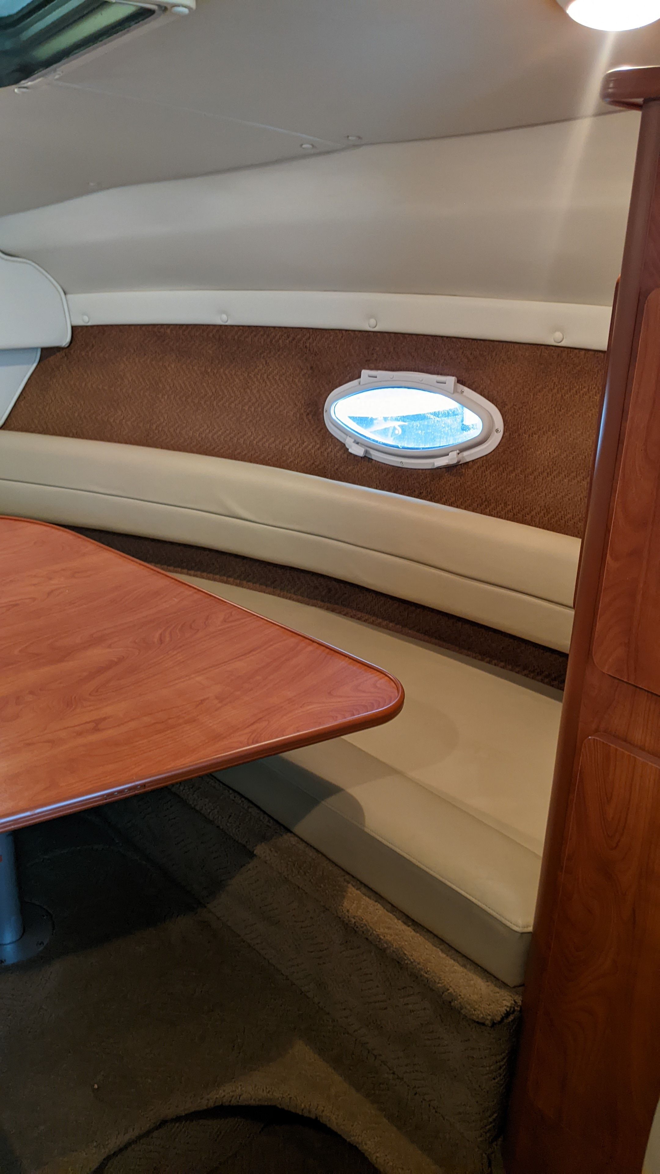 Interior of a 2006 Rinker 250 EC with wooden table and seating.