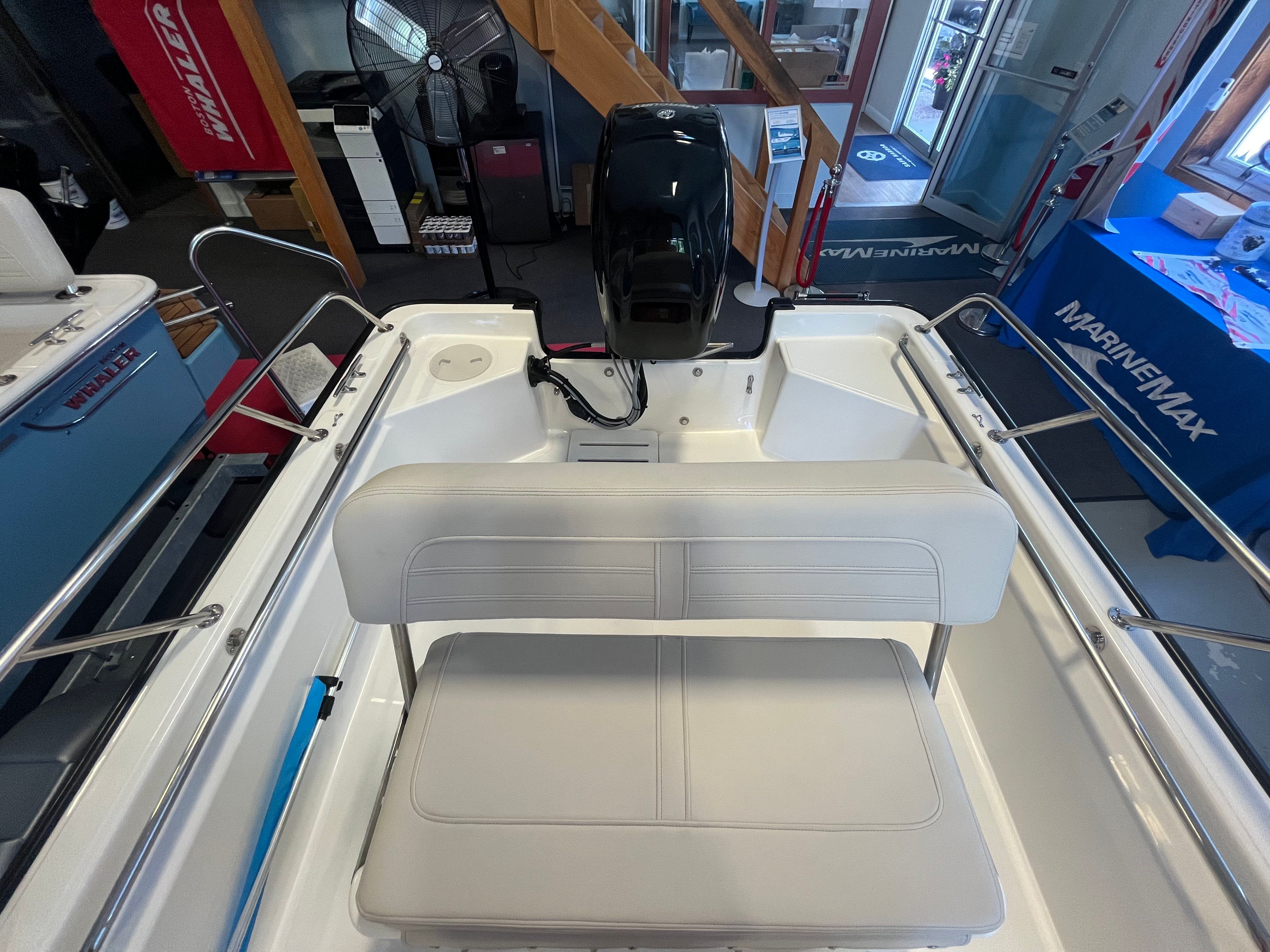 Interior view of a Boston Whaler 150 Montauk with white bench seat and helm console.