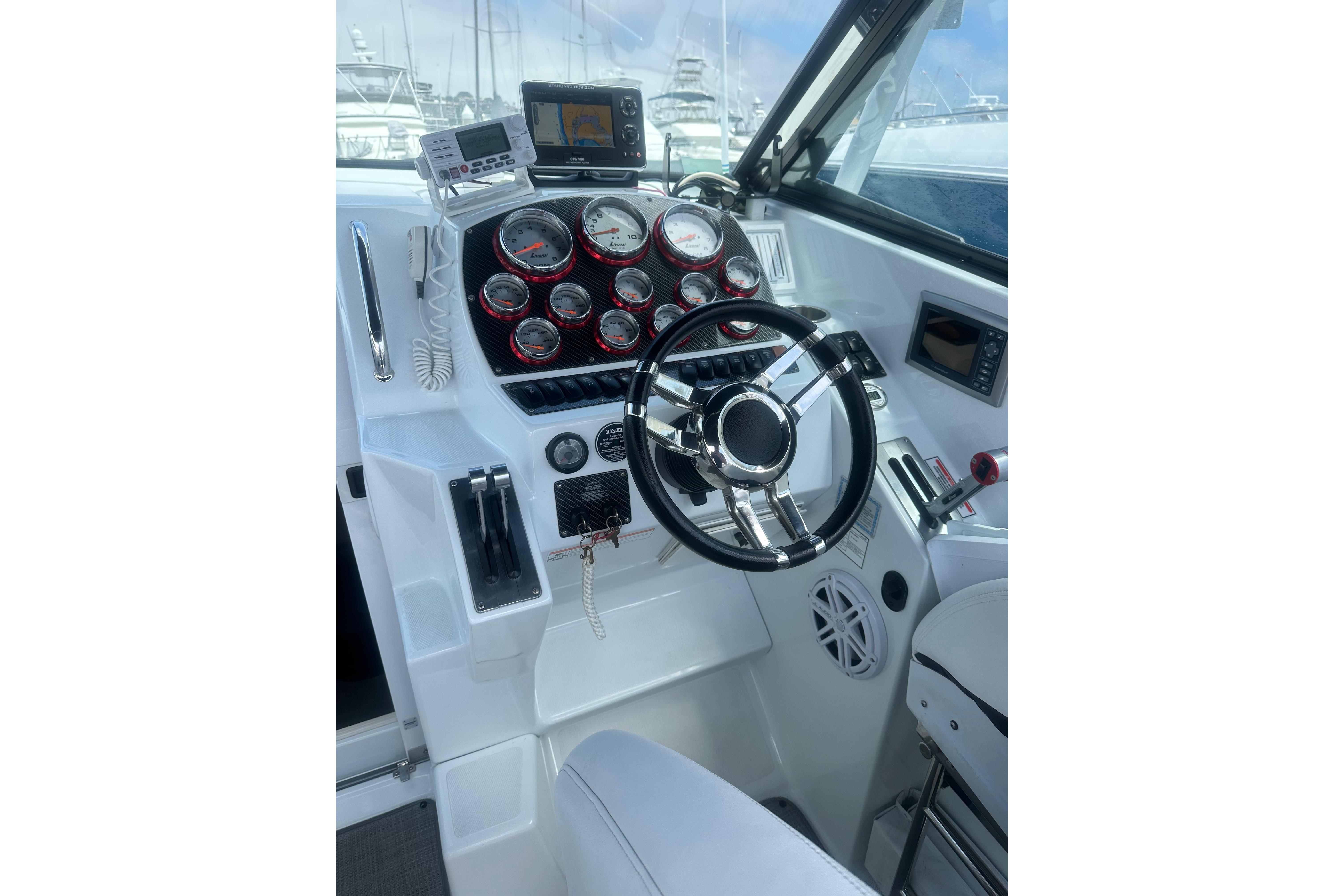 Cockpit of 2008 Baja 30 Outlaw boat with steering wheel and gauges.