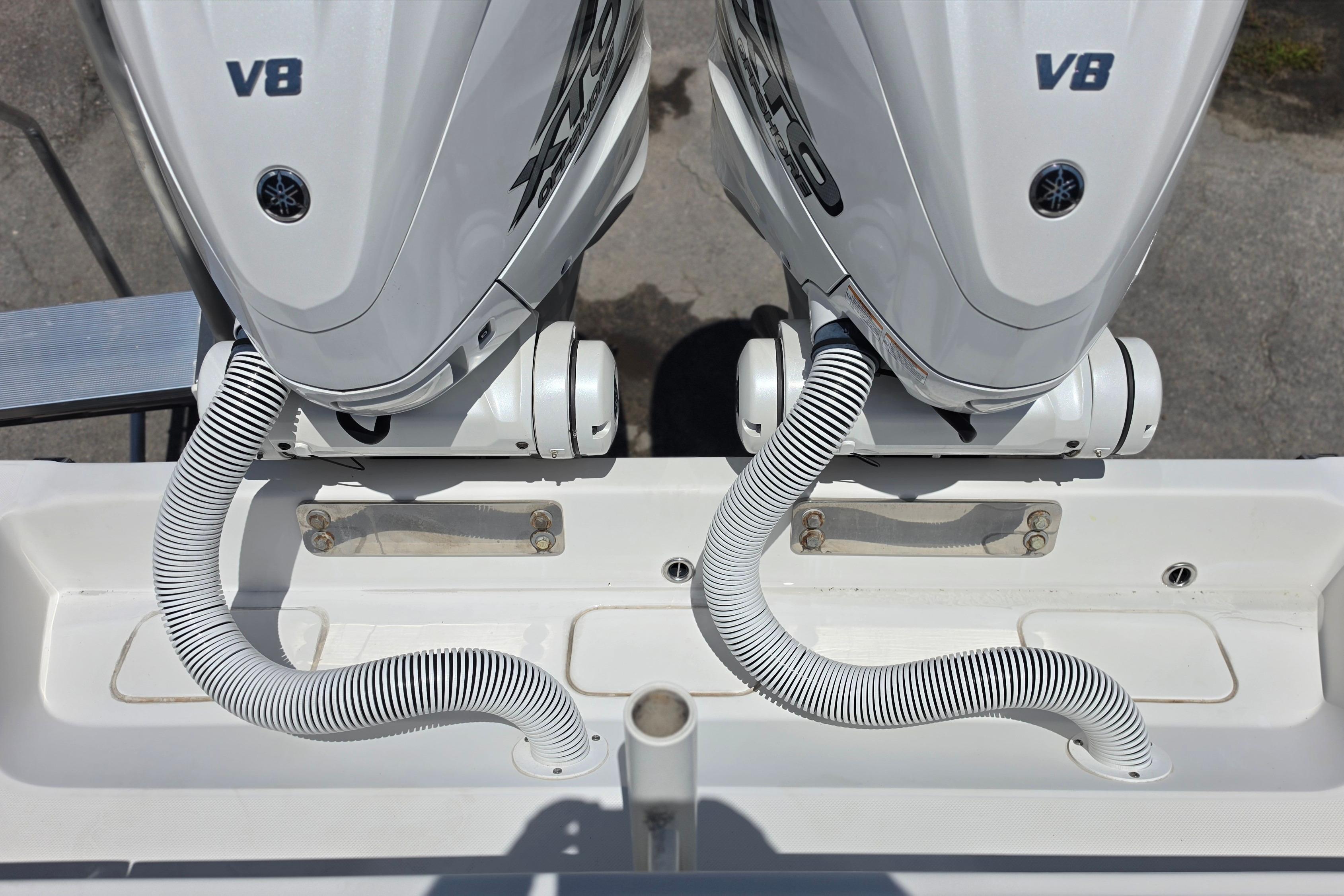 Twin V8 outboard engines on a 2020 Jupiter 34 HFS boat, featuring coiled hoses.