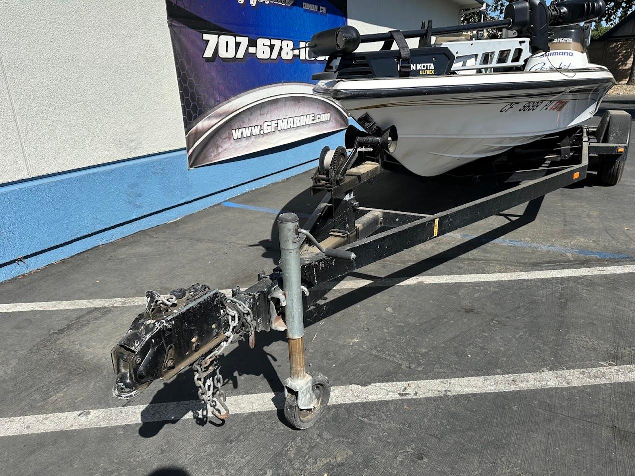 1999 Fisher 21 FX DC boat on trailer, parked outdoors near a blue and white building.
