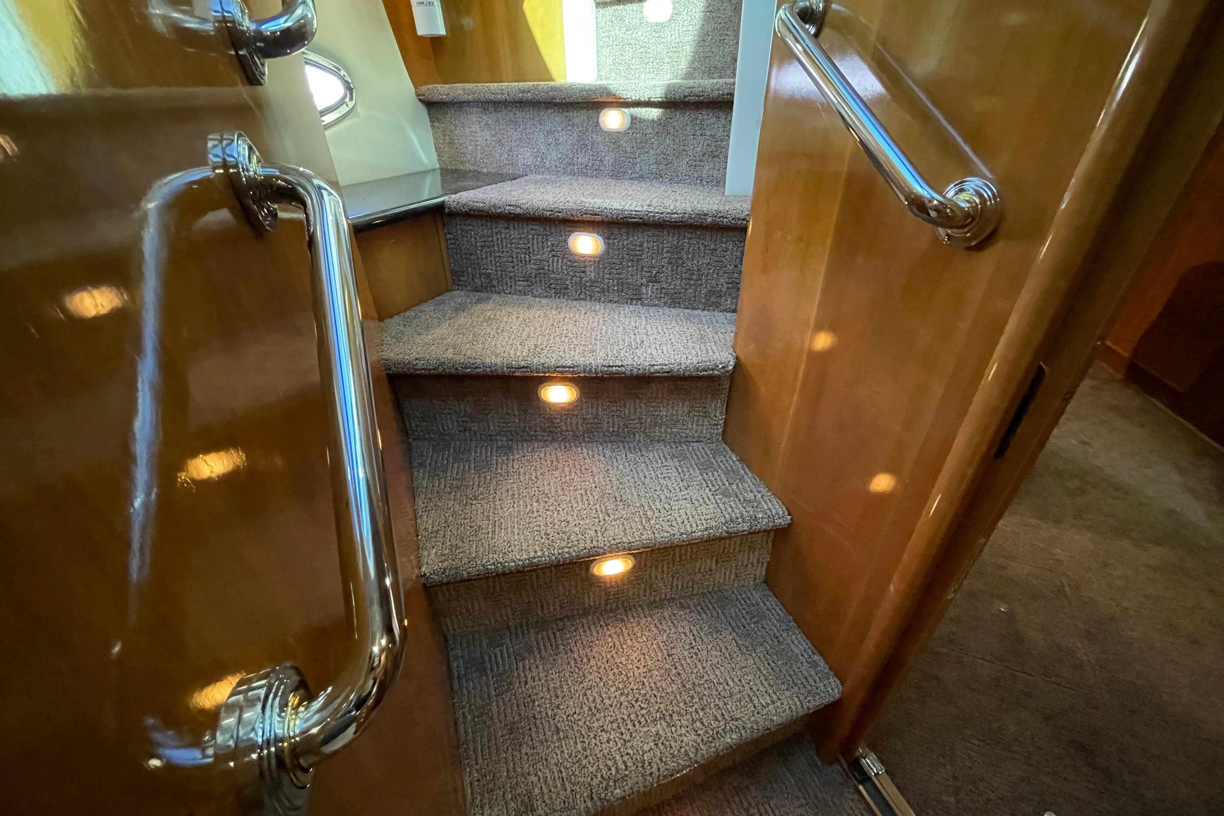 Carpeted stairs with lights on a 2002 Carver 570 Voyager Pilothouse yacht.