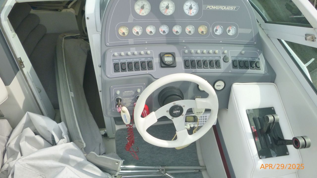 The image shows the cockpit of a 1992 Powerquest 270 Laser boat with steering wheel and instruments.