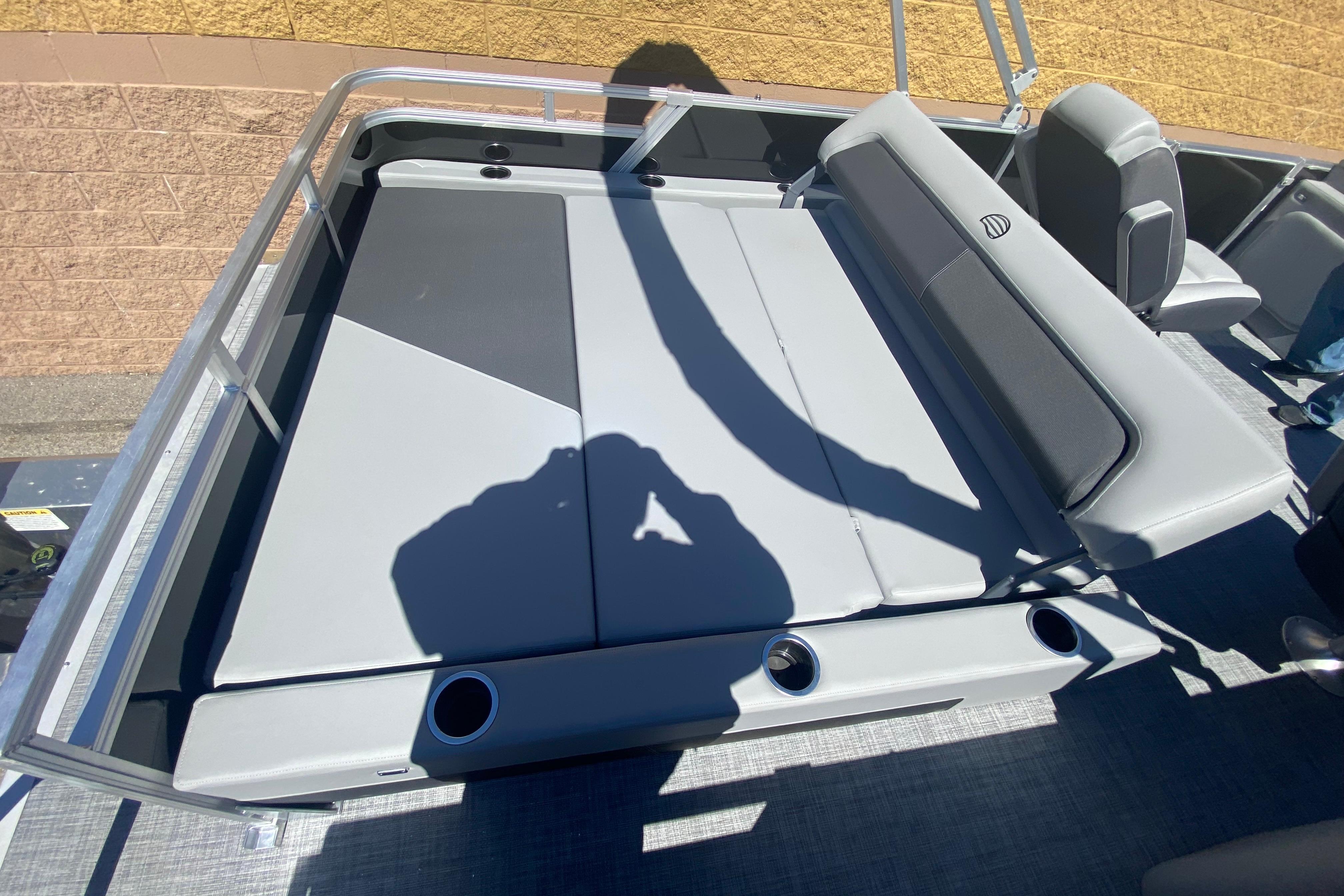 2026 Sun Tracker Party Barge 22 RF DLX interior with gray seating and cup holders.
