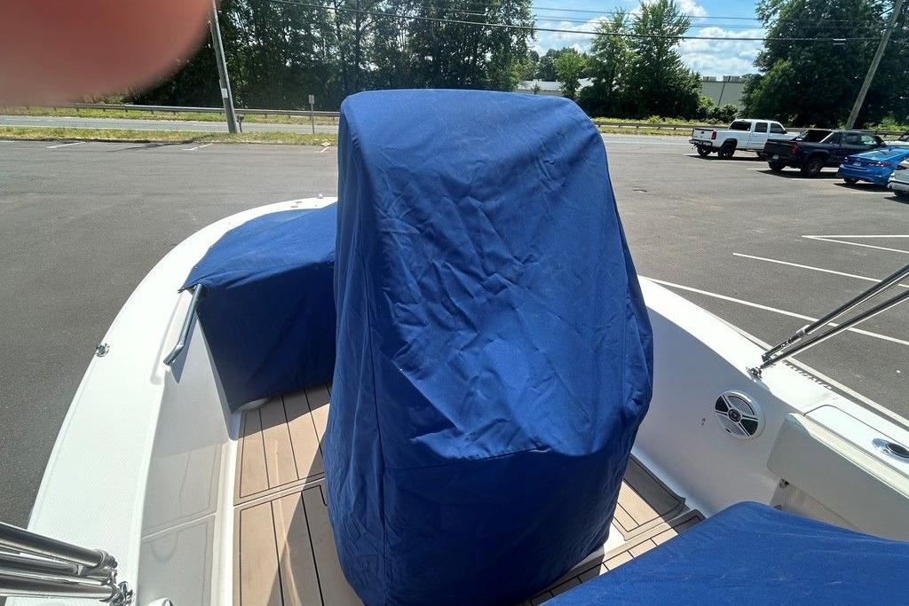 2017 Robalo R200ES boat with blue covers in a parking lot.