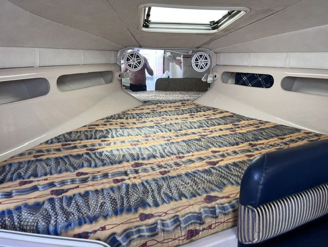 Interior of a 1999 Doral 300sc featuring a cozy bed and speakers.