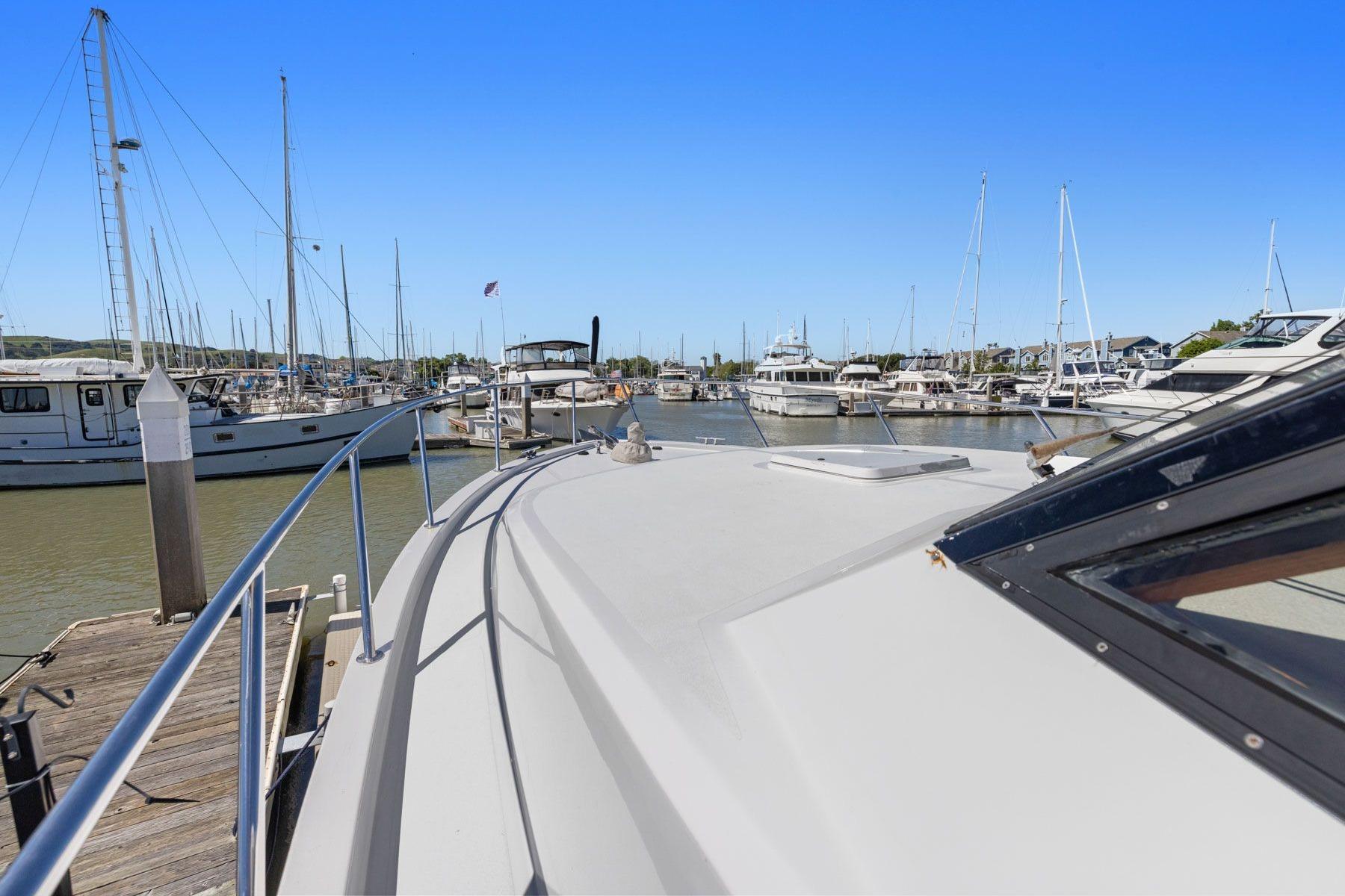 Ocean Alexander 520 Pilothouse yacht docked at marina, surrounded by sailboats, clear blue sky.